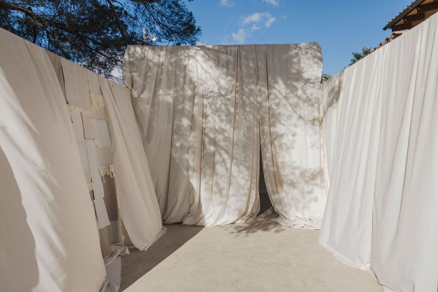 White fabric drapes create an elegant outdoor wedding ceremony space.