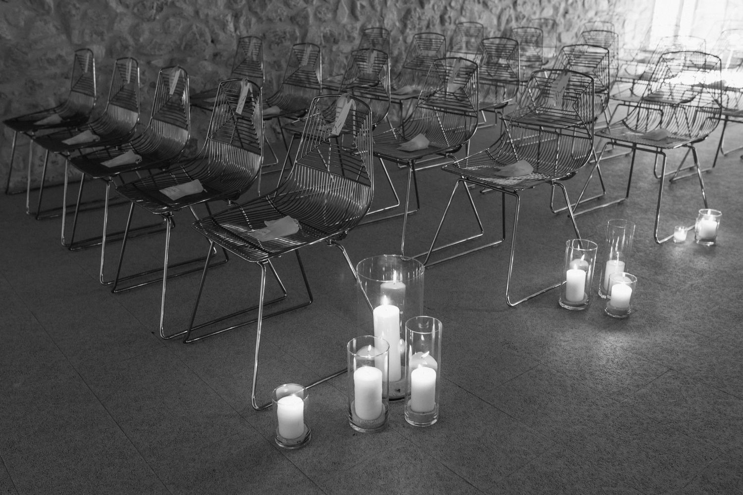 Glass lanterns with candles illuminate an outdoor seating area at dusk creating a romantic ambiance.