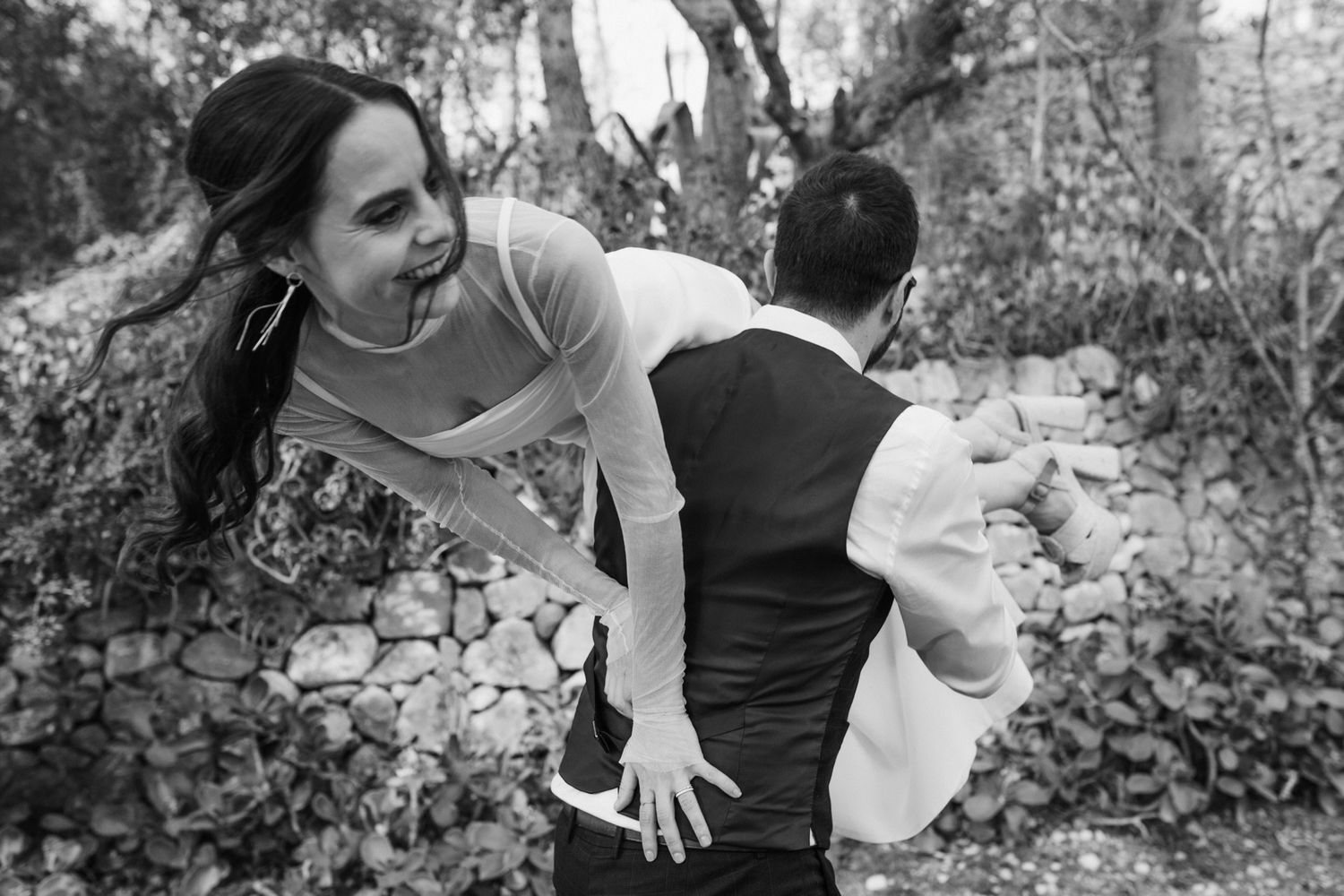 Black and white photo series showing playful and intimate moments between a couple in an outdoor garden setting.
