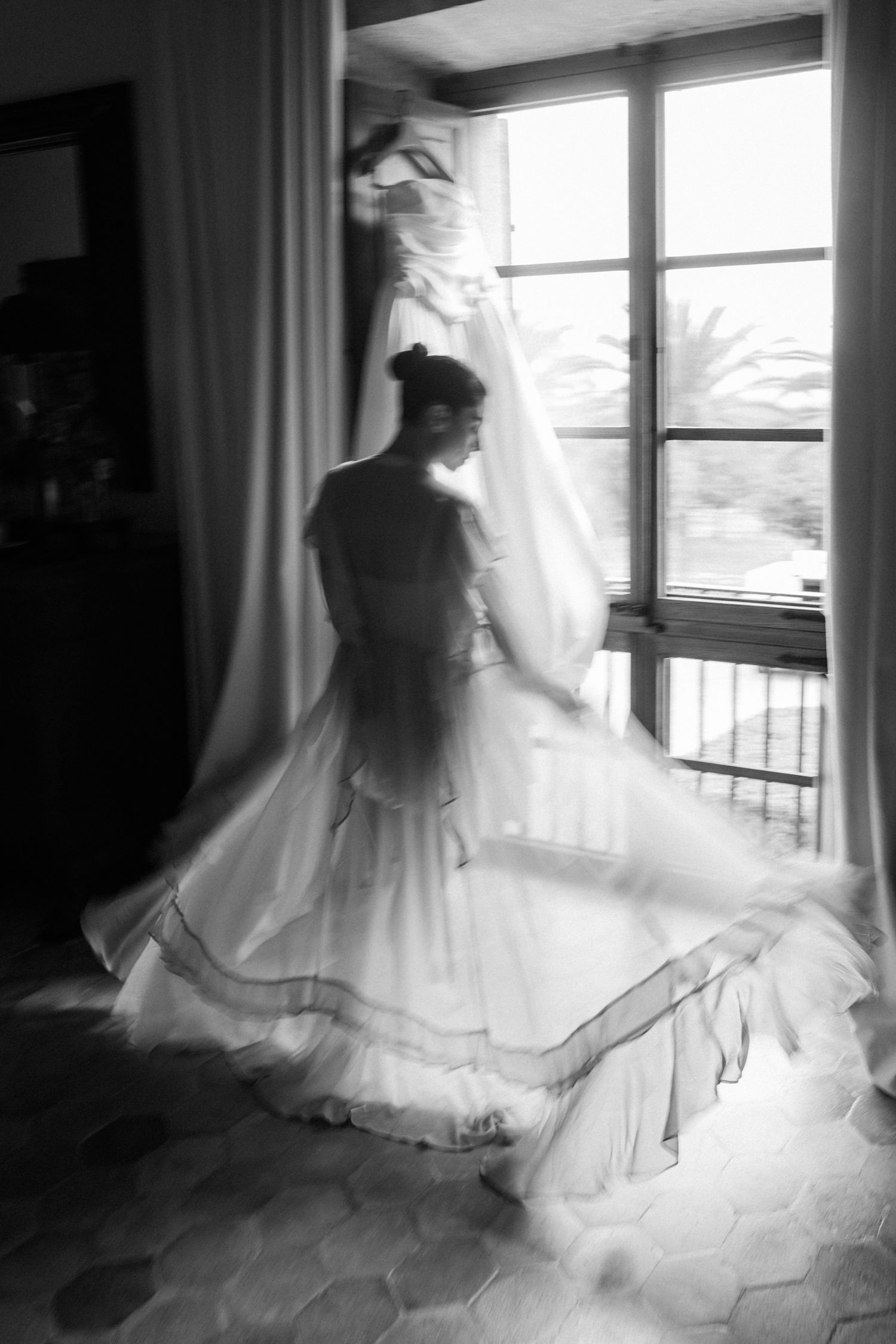 A series of black and white photos showing a flowing white wedding dress silhouetted against a bright window.