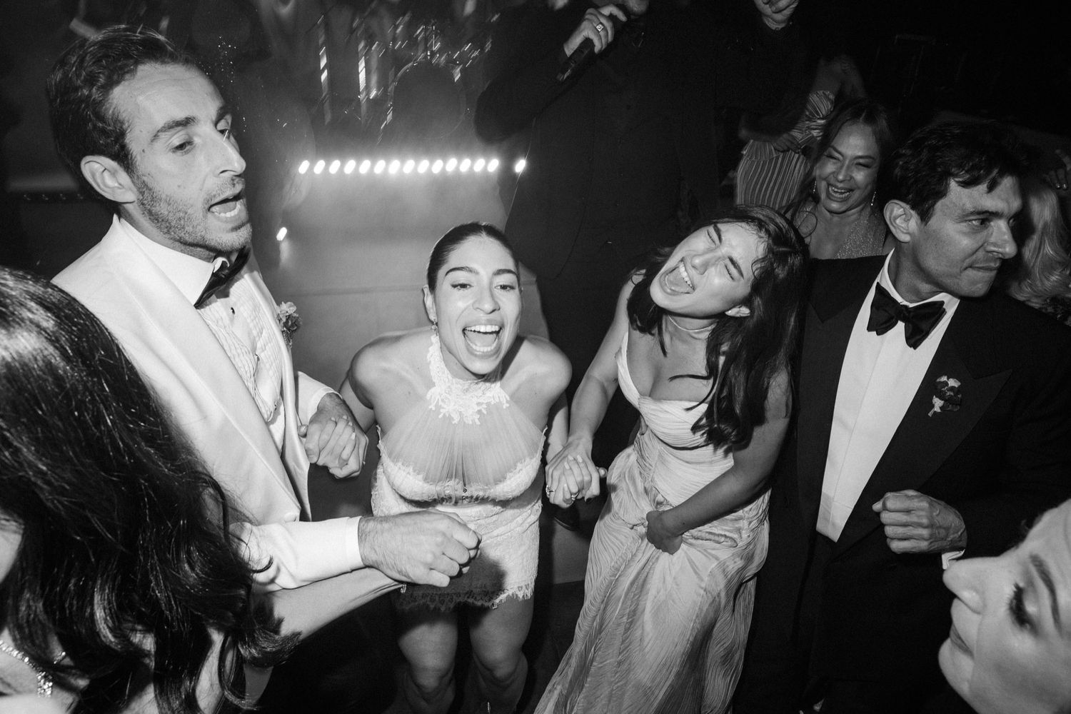 Black and white photos capture joyful dancing moments at an elegant wedding celebration.
