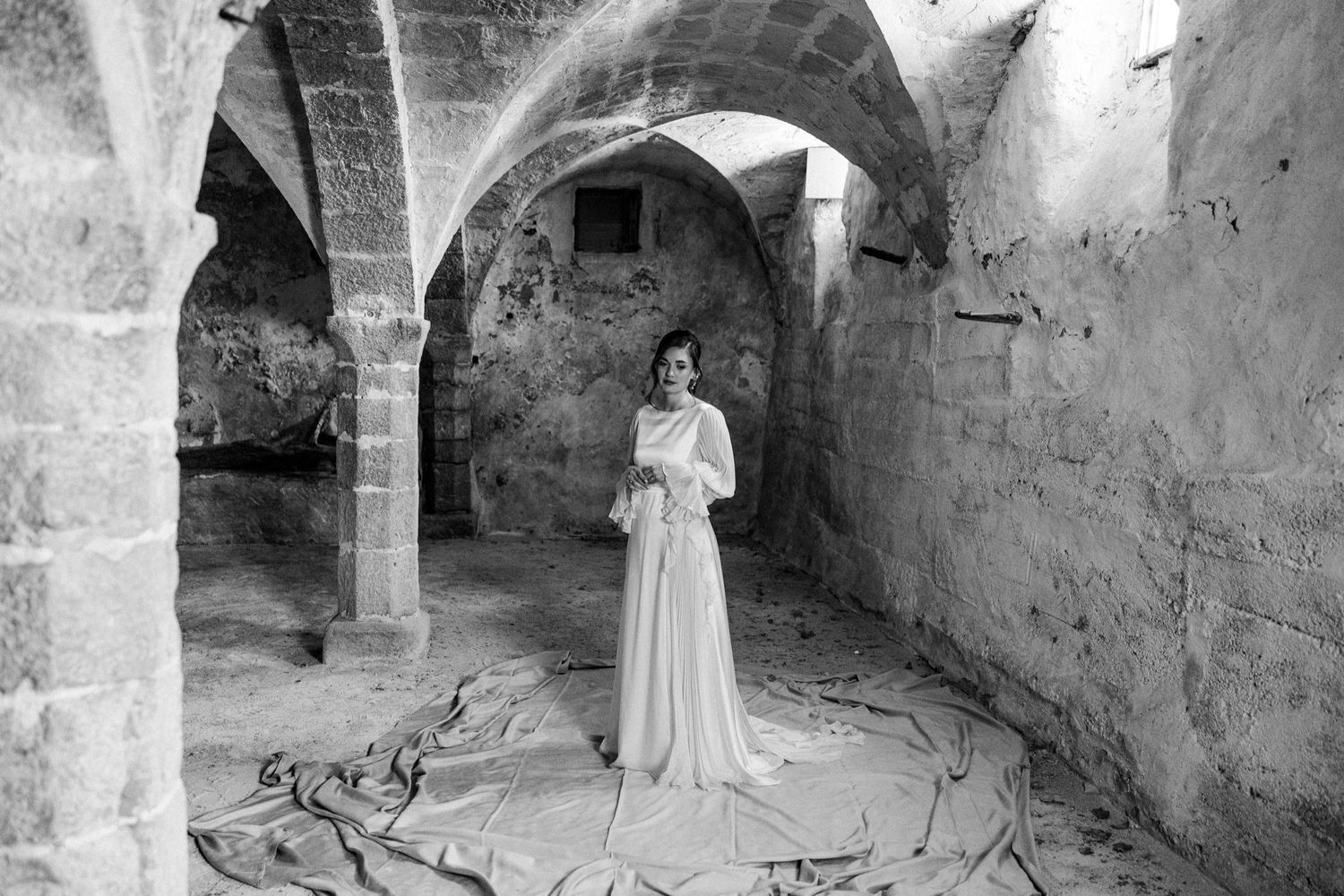 A series of black and white photographs showing stone arches and architectural details in an ancient underground space.