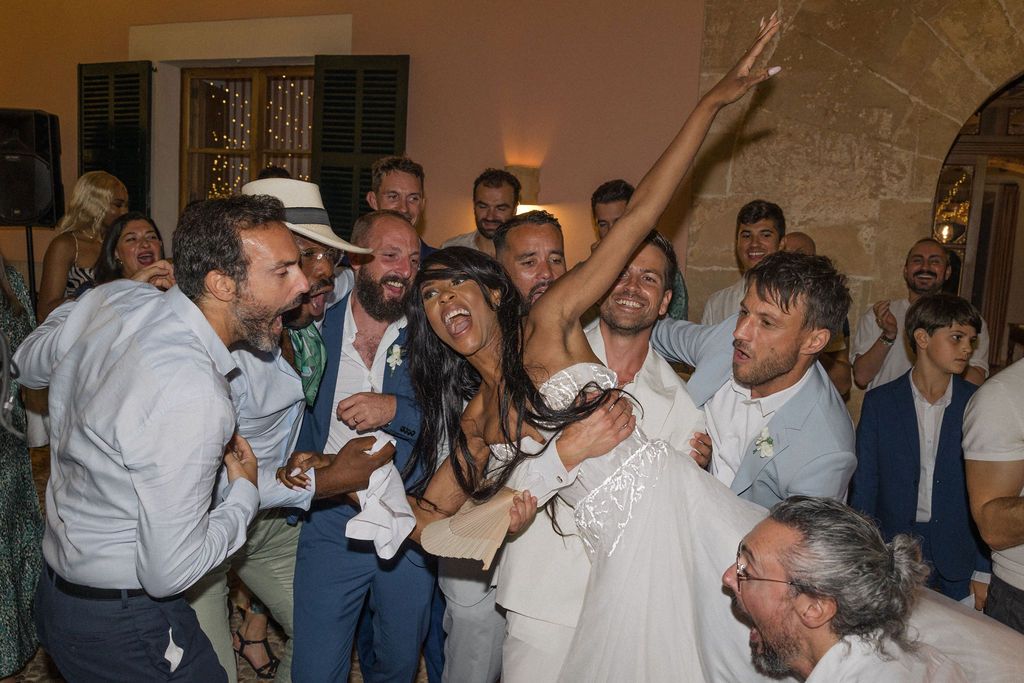 Wedding party celebrates with drinks and dancing during a lively reception.