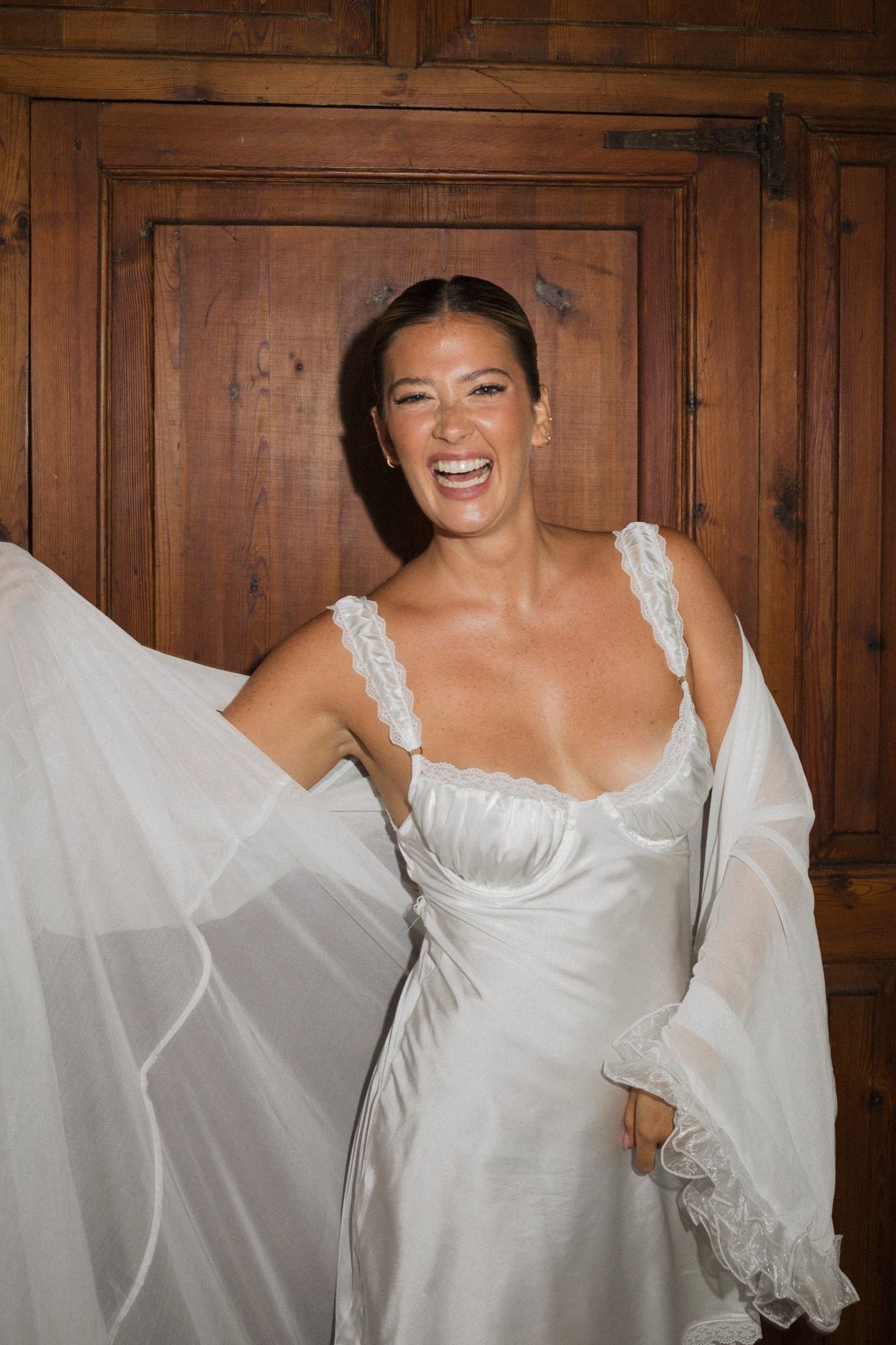 Sequence showing white dress details against rich wooden paneling.