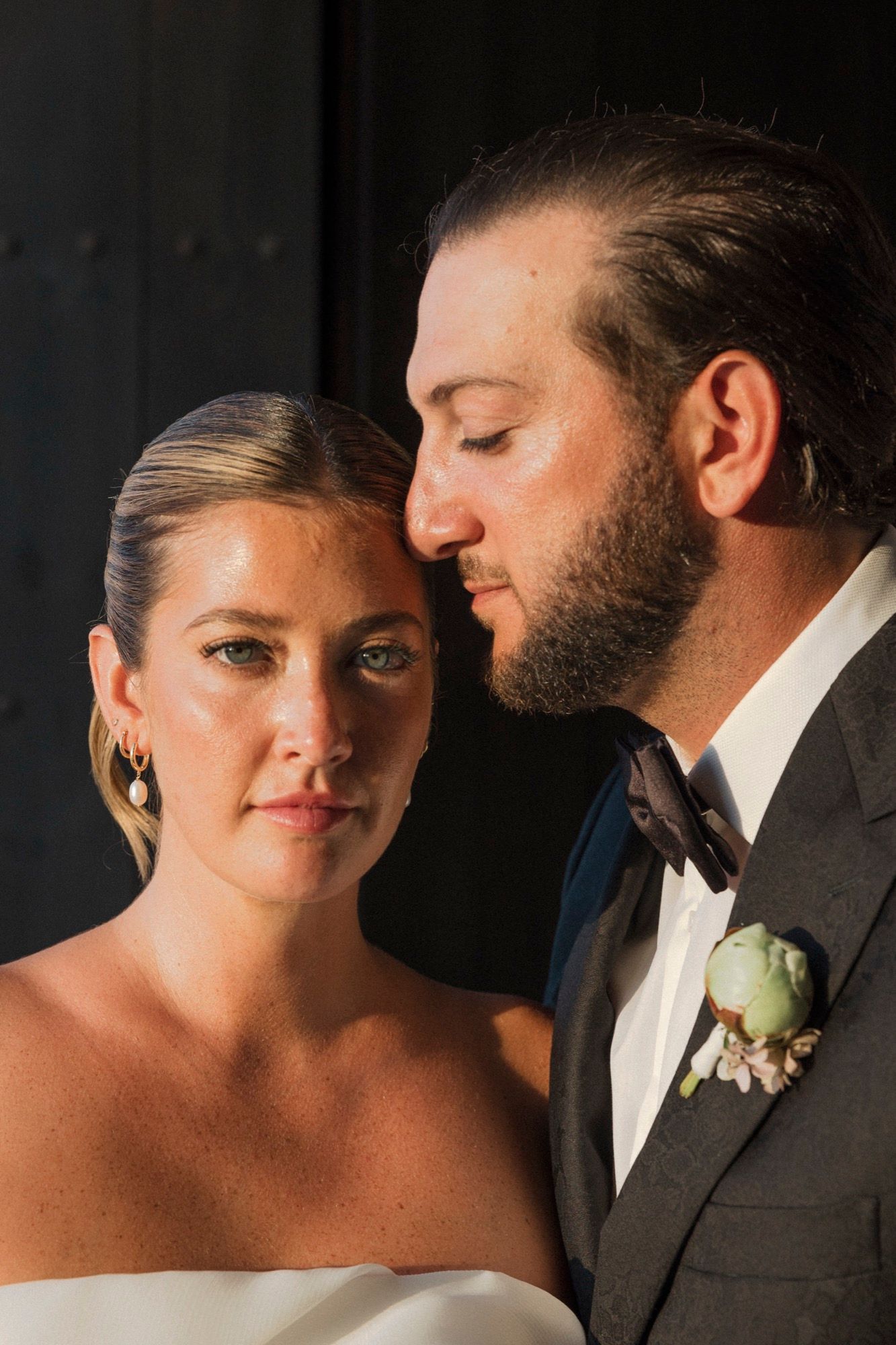 An elegant wedding portrait capturing a close-up intimate moment between bride and groom.