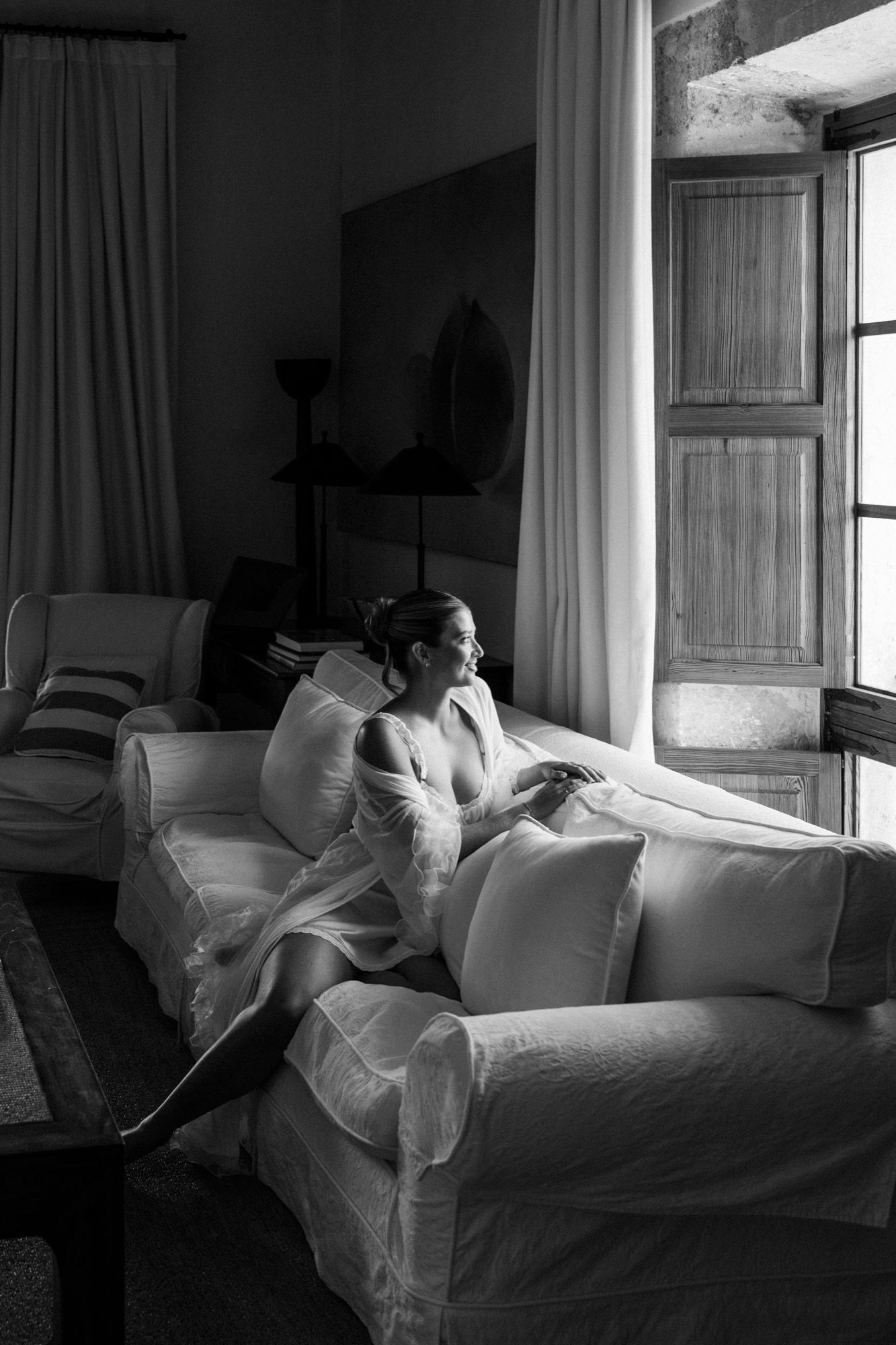 Artistic black and white photo of flowing white fabric in a sunlit room.