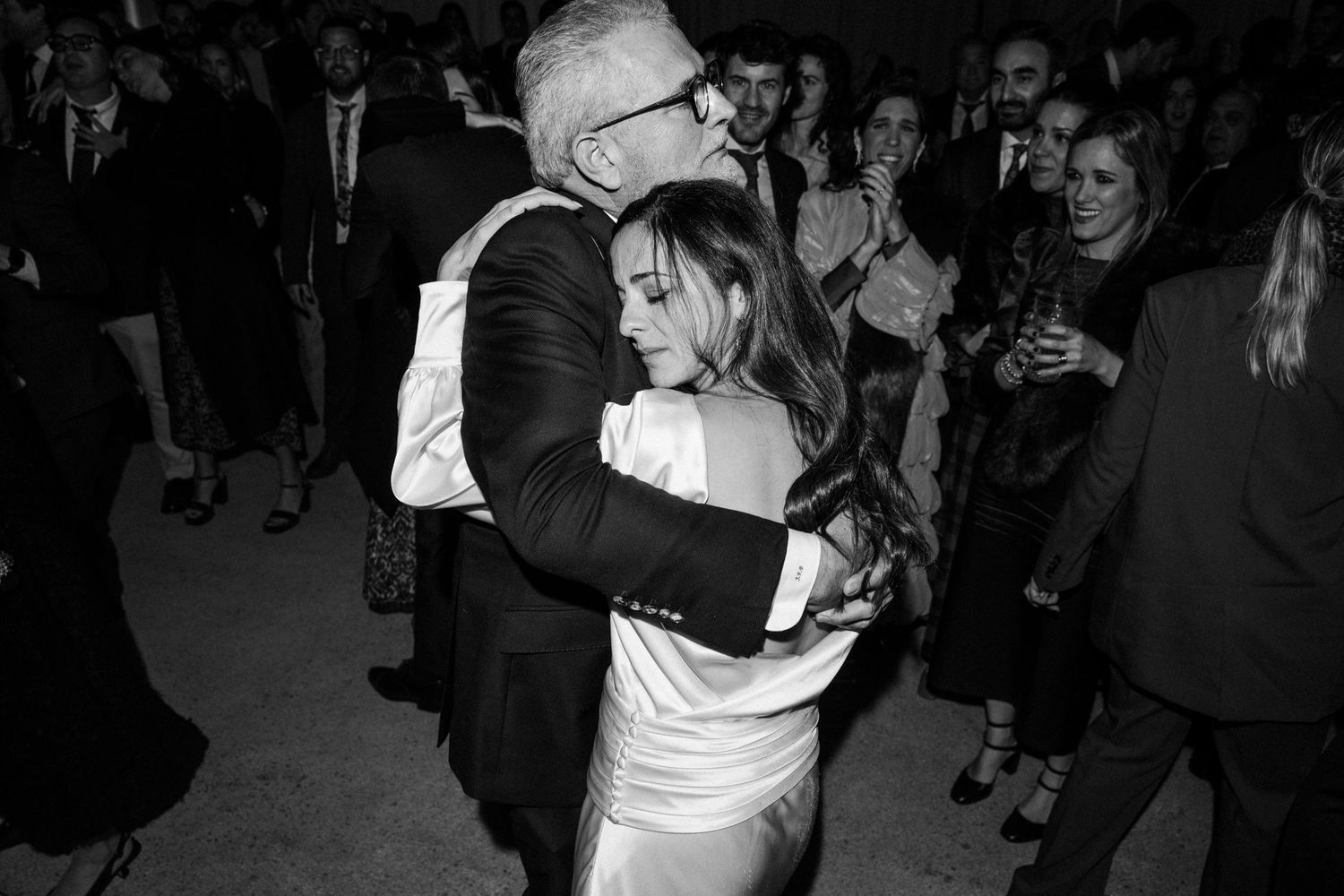 A couple shares an intimate dance moment at a formal event in black and white photography.