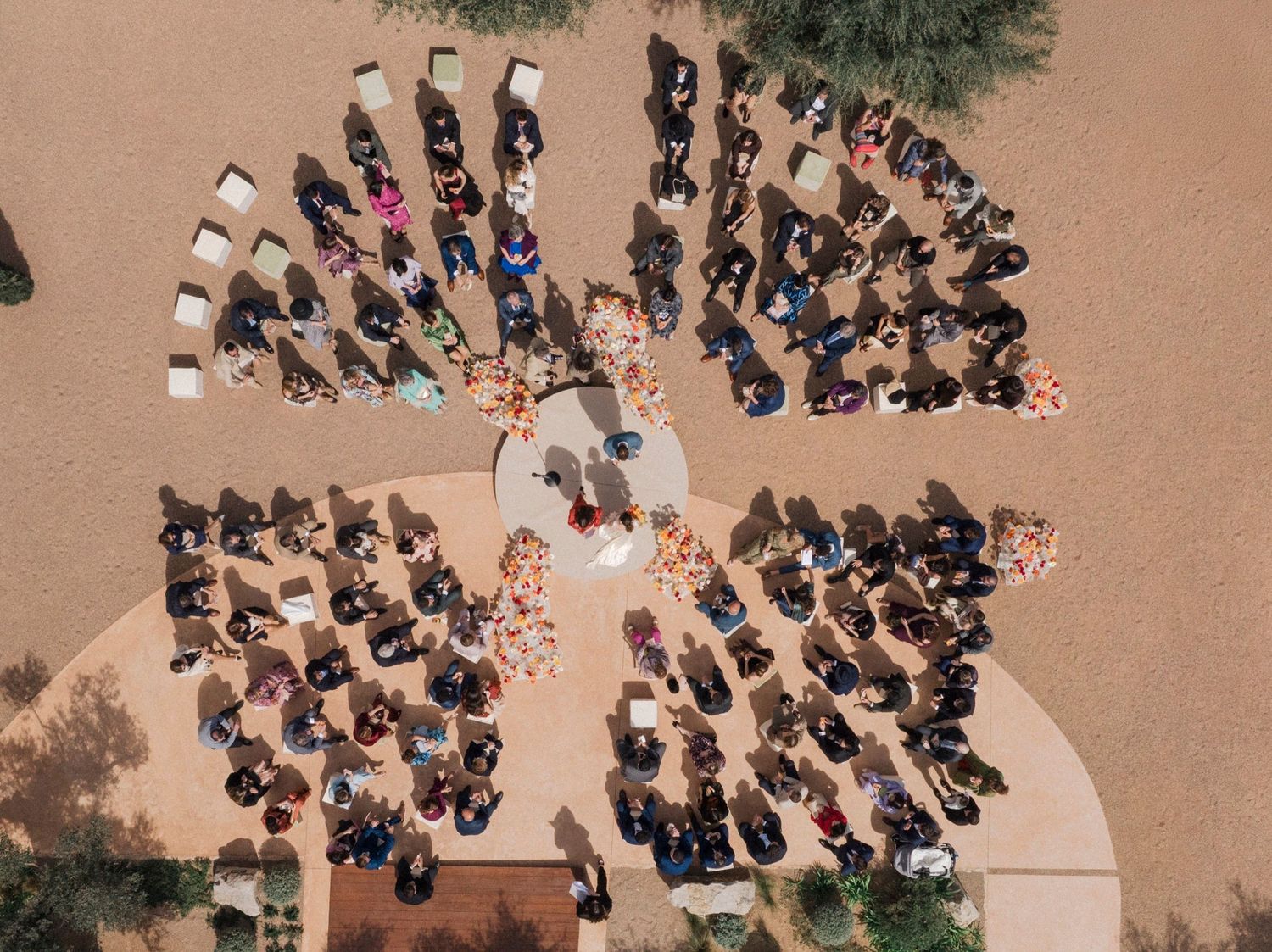 Aerial view of people gathered in a circular formation for an outdoor ceremony or event.