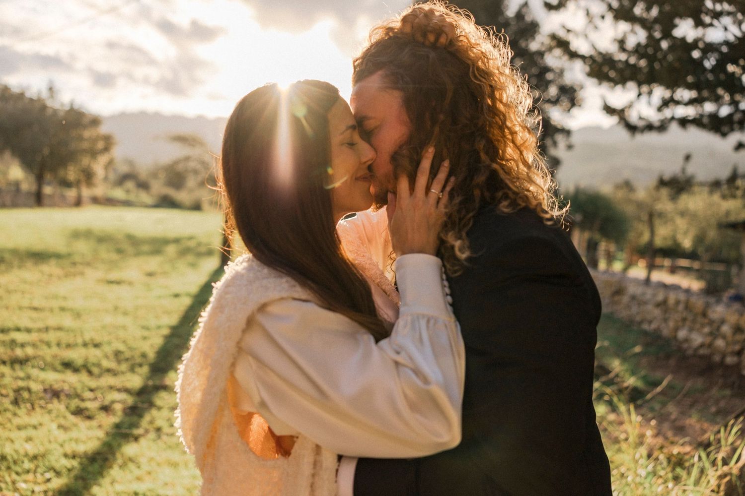Golden hour wedding photos capture romantic moments between newlyweds in a pastoral setting.