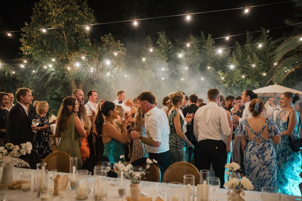 Outdoor wedding reception with string lights creating a magical evening atmosphere.