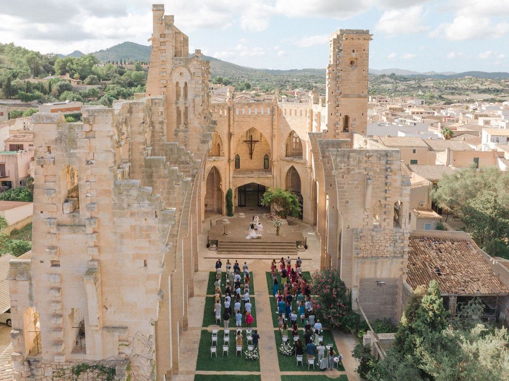 Ancient stone castle courtyard with Gothic architecture and outdoor seating arranged for a special event.