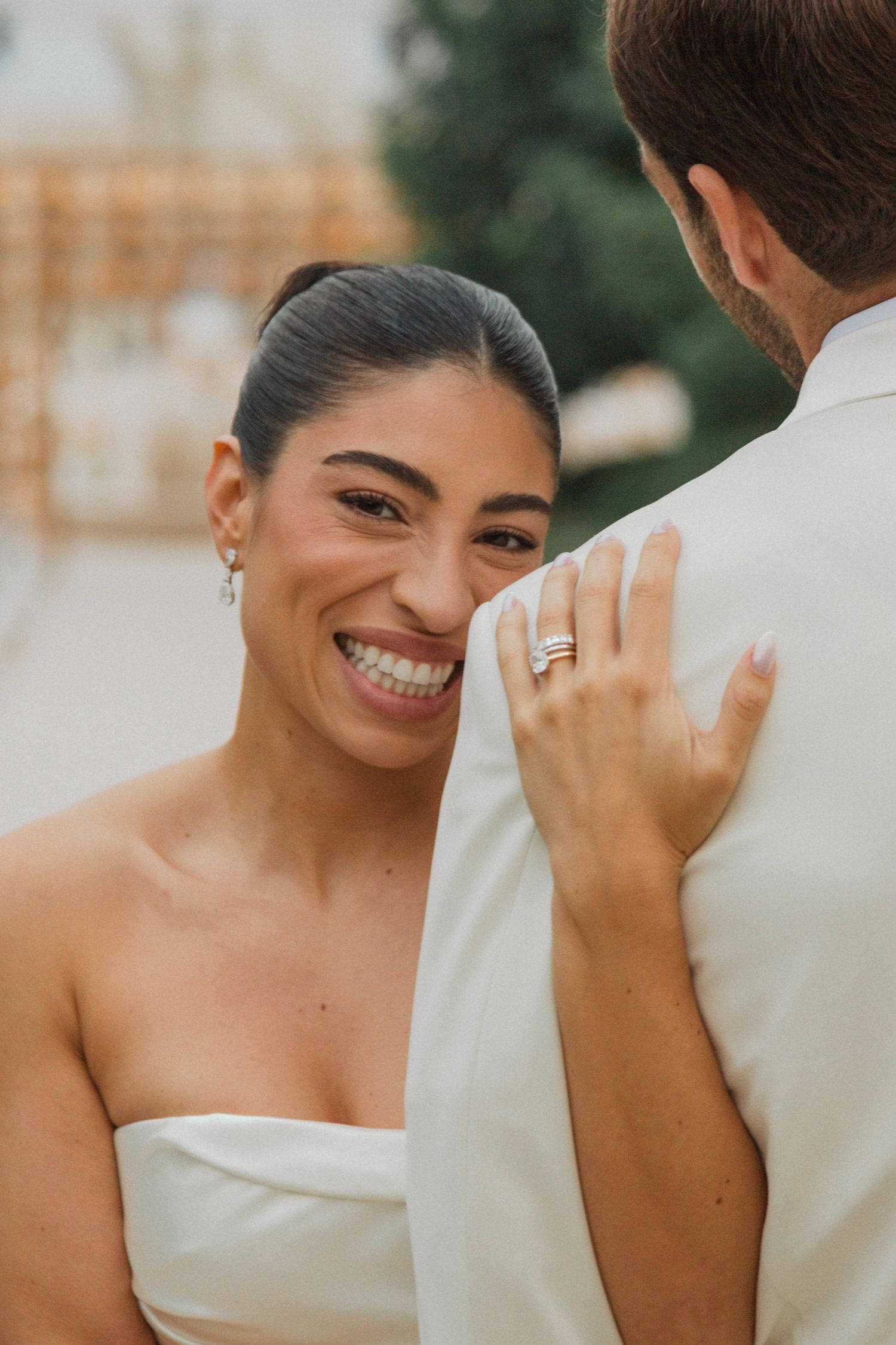 A joyful bride in a white strapless gown smiles radiantly in a series of candid wedding photos.