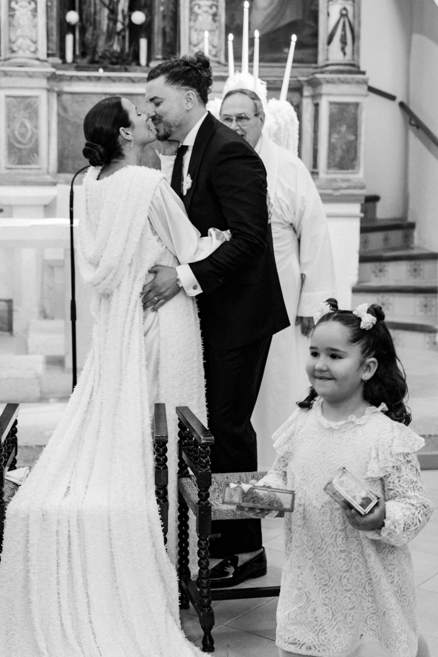 Wedding ceremony scene with flower girl and formal decorations in church setting.