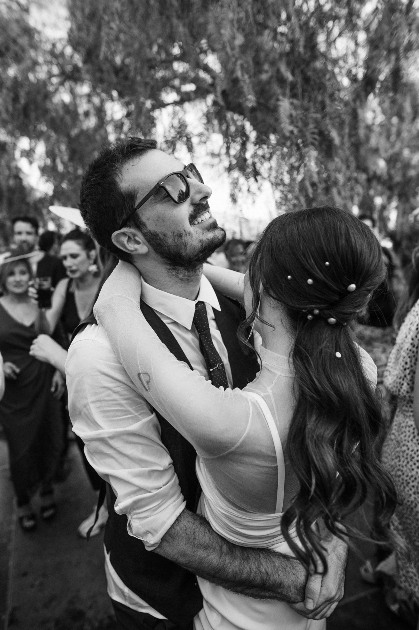 A romantic sequence of black and white photos showing a couple dancing and embracing at an outdoor celebration.