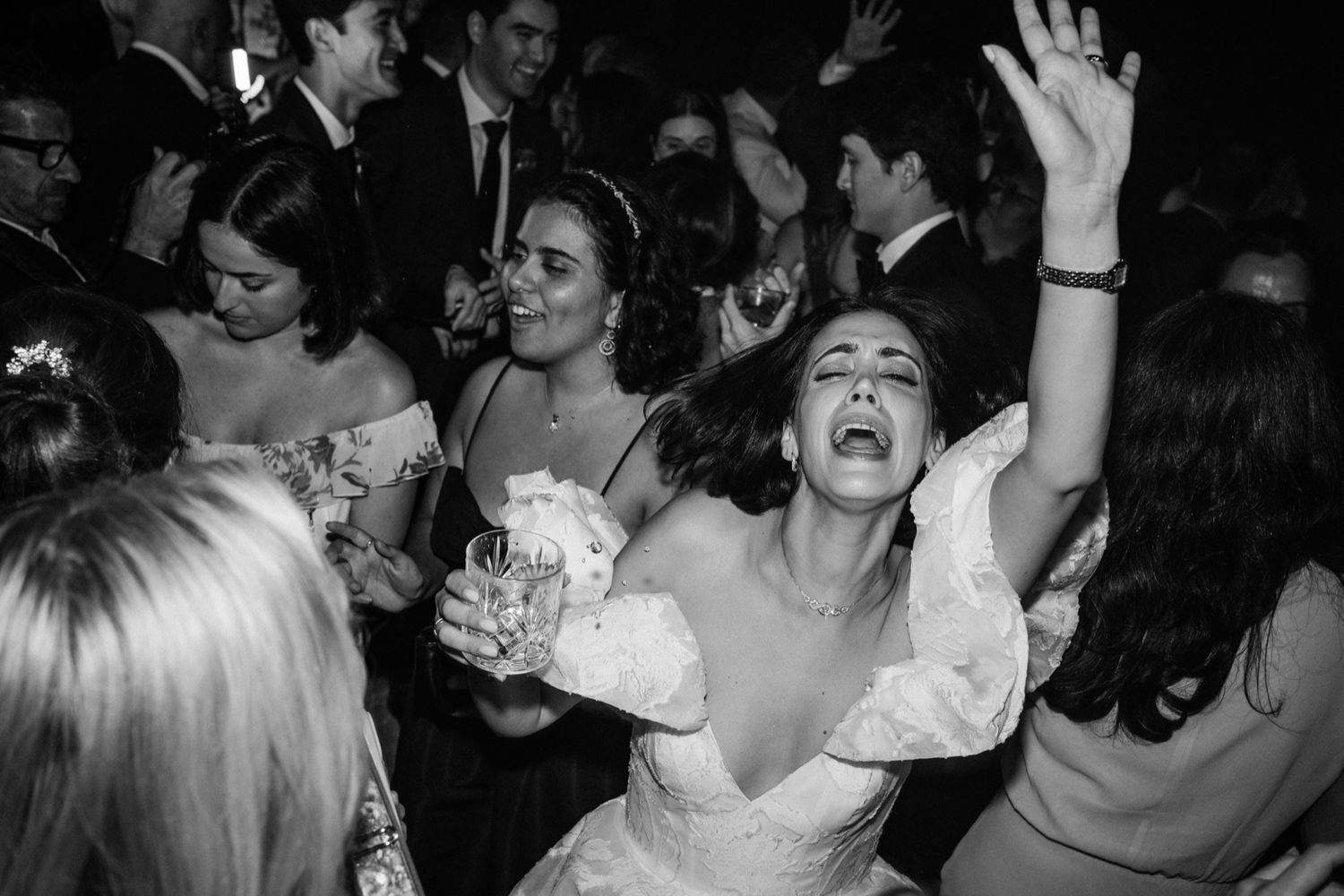 Black and white photos show people dancing and celebrating energetically at a nightclub or party venue.