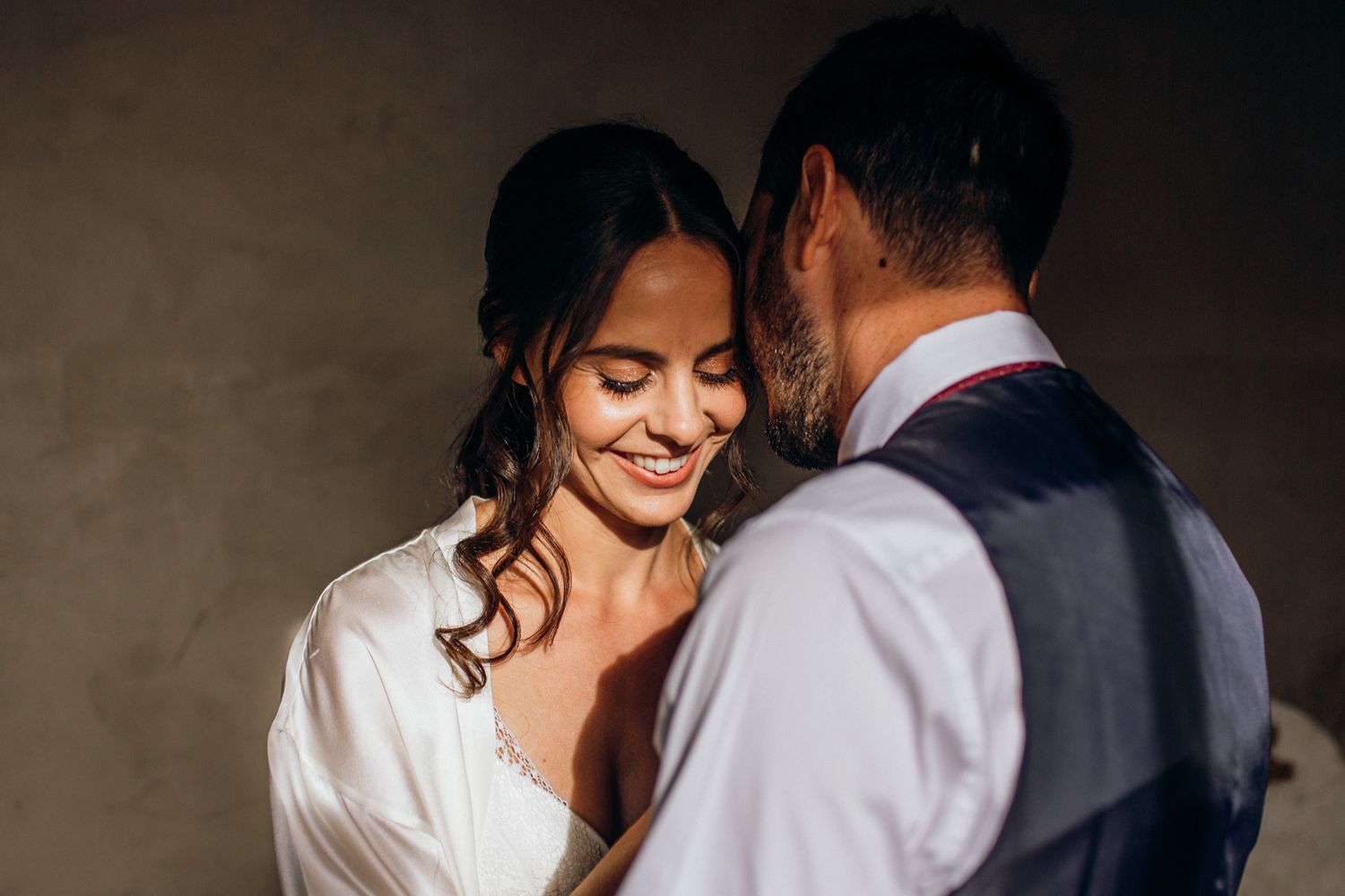 A couple in wedding attire shares an intimate moment while posing for photos during their special day.