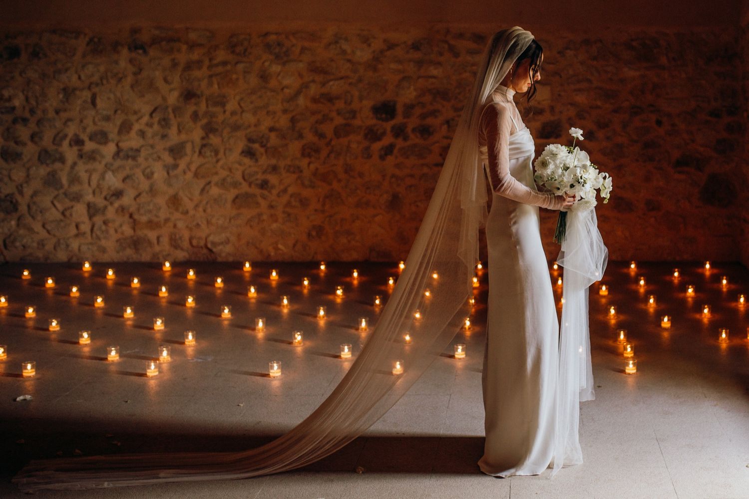 String lights illuminate a rustic brick wall interior creating a romantic ambiance for a wedding celebration.