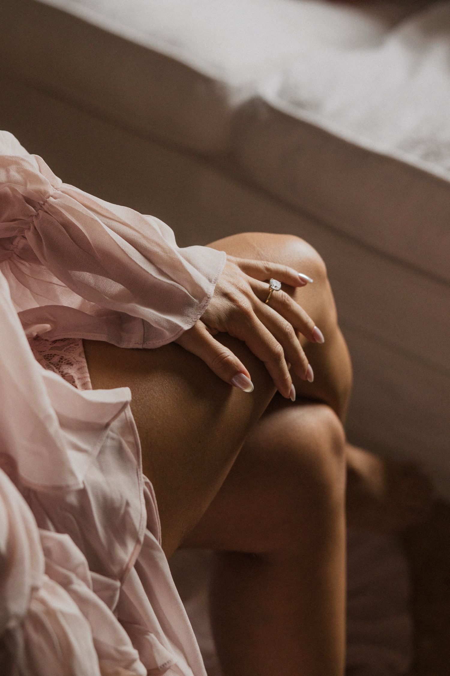 Artistic sequence of hands touching a brown leather couch with flowing sheer pink fabric creating ethereal movement.