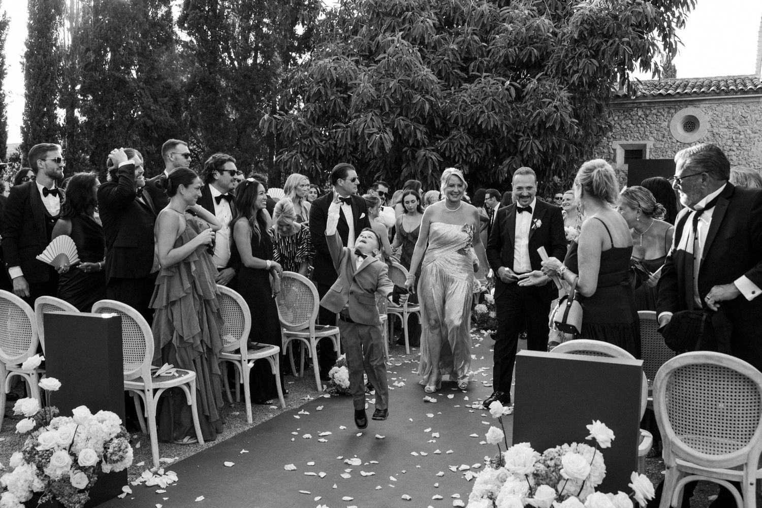 Black and white wedding celebration photos showing guests at outdoor venue.