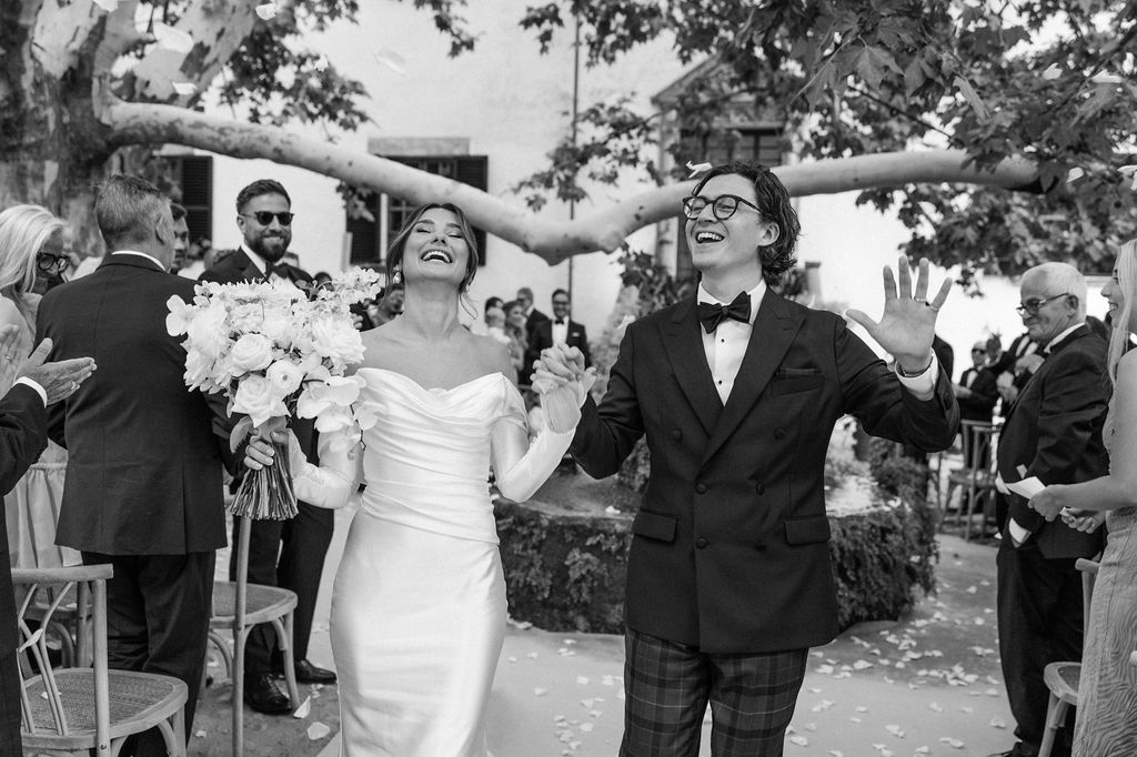 Joyful wedding celebration captured outdoors with natural greenery backdrop.