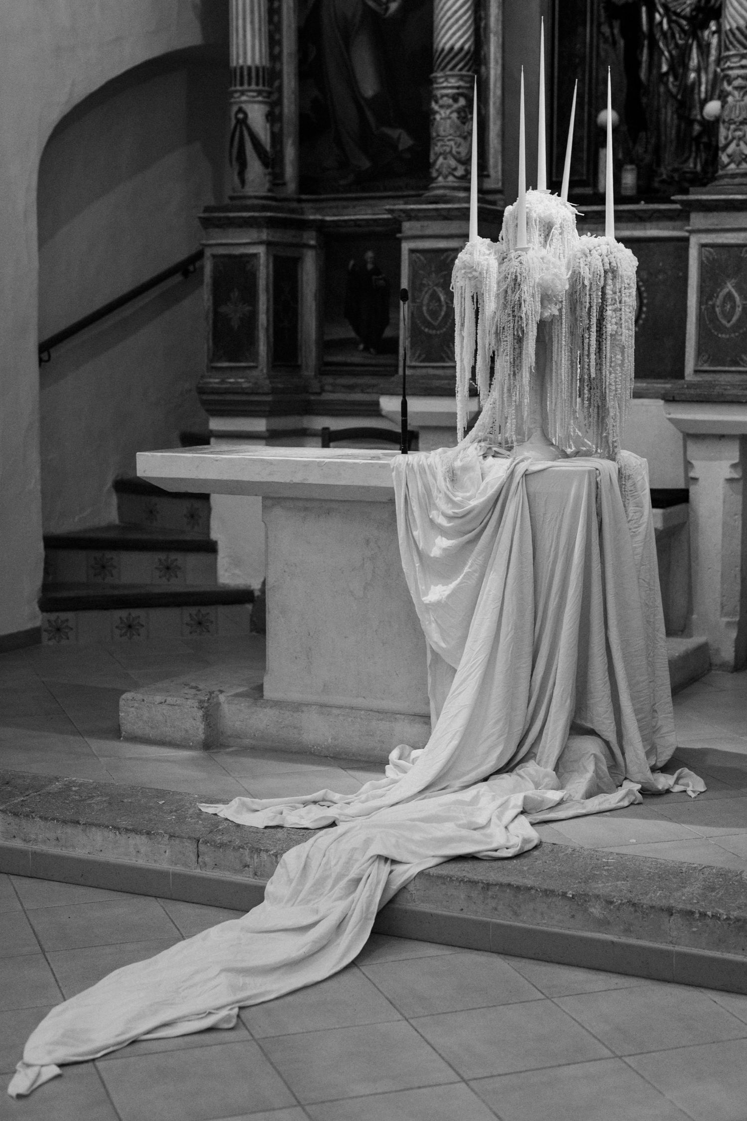 Dramatic white fabric installation cascading down church altar steps.