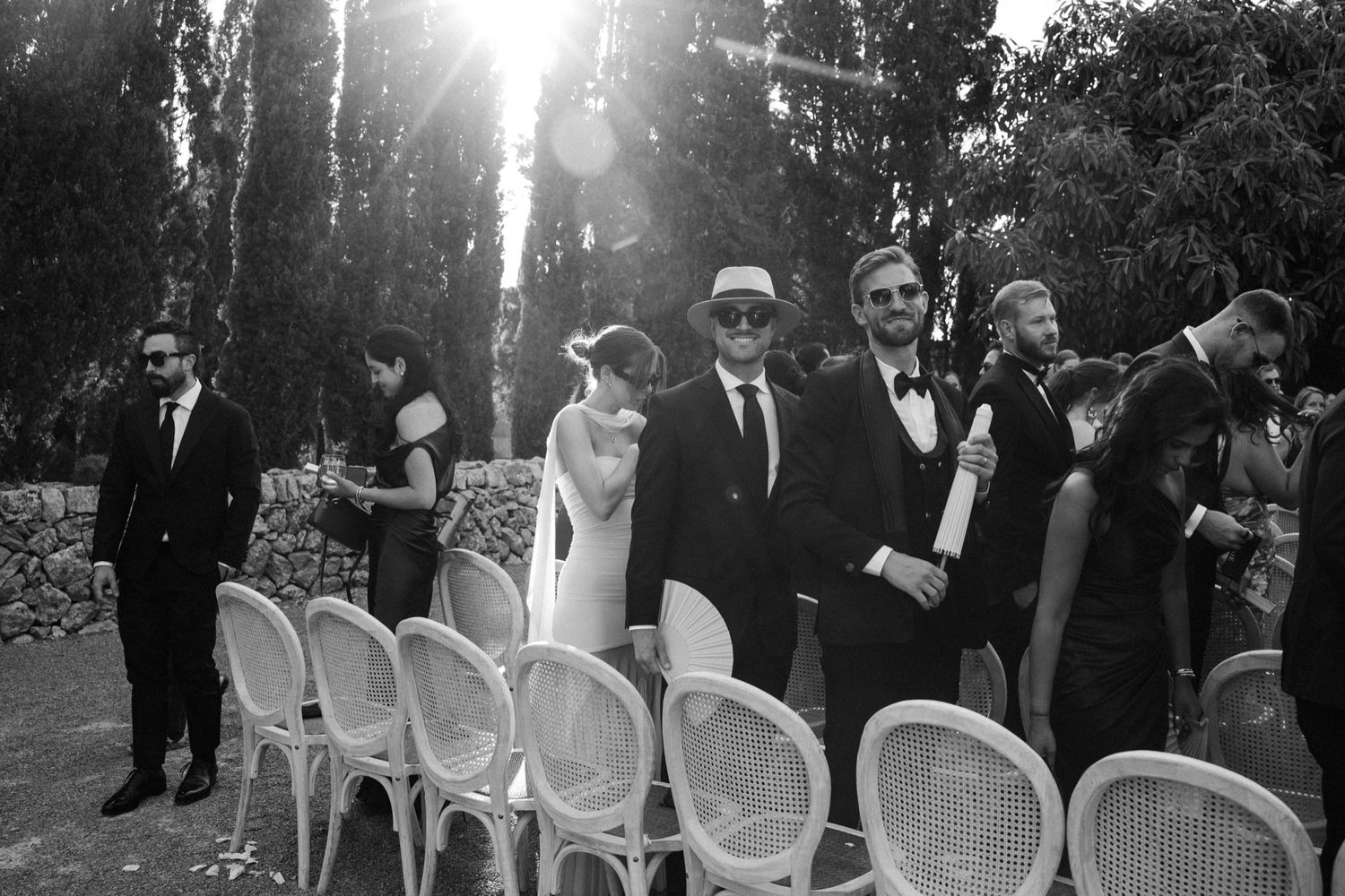 Sunlit outdoor wedding venue with white chairs and natural lighting.