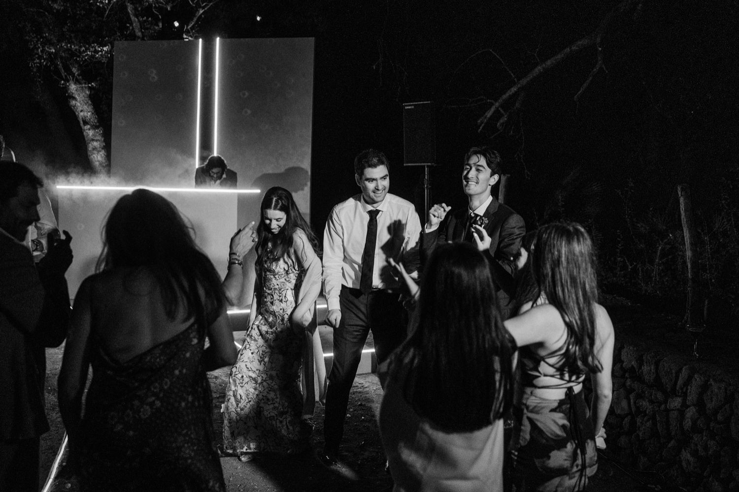 A series of black and white photographs showing people in a dark, moody setting at a social gathering or event.