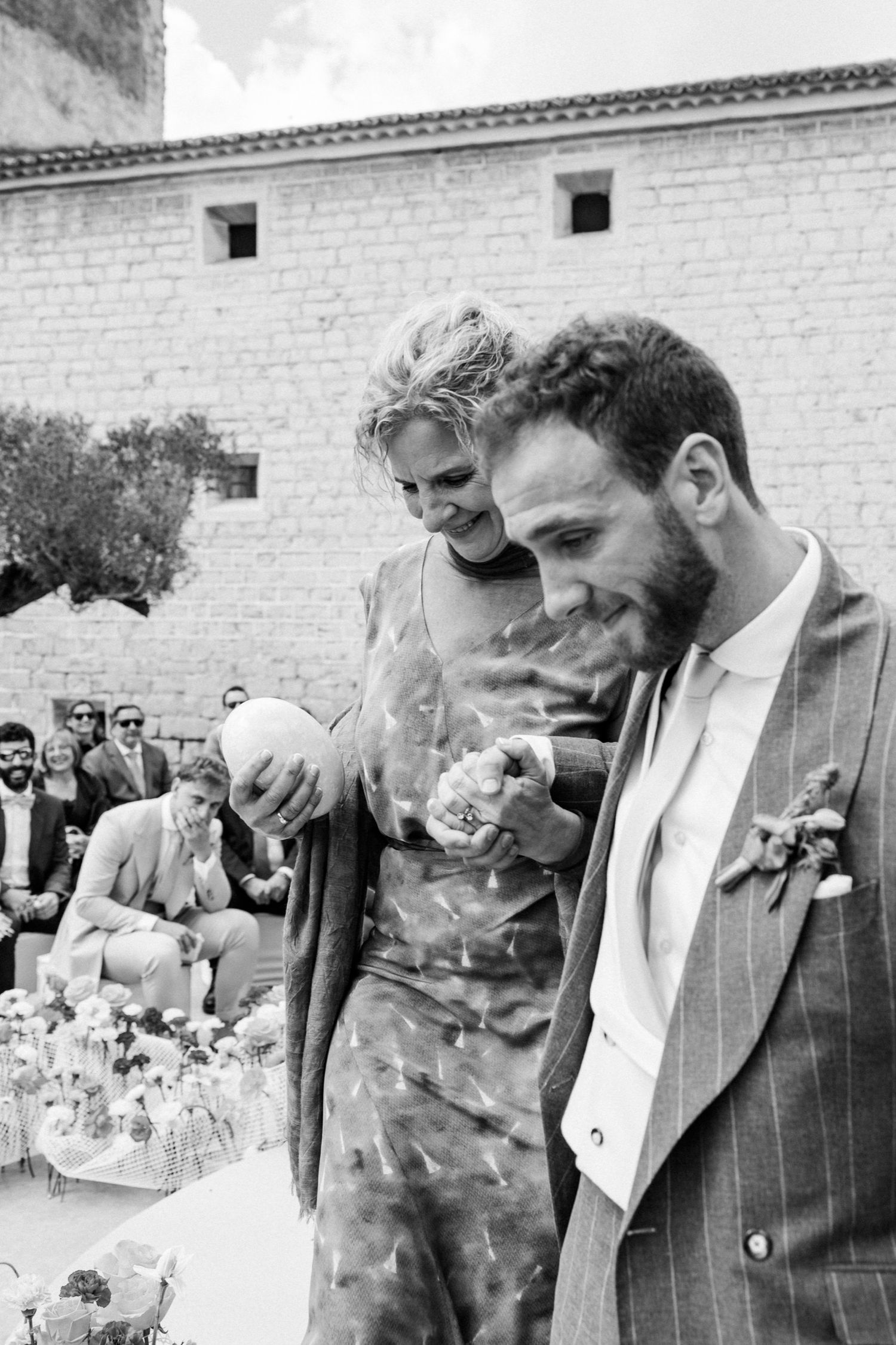 Black and white wedding photo series showing a couple sharing a tender moment in front of a brick wall.
