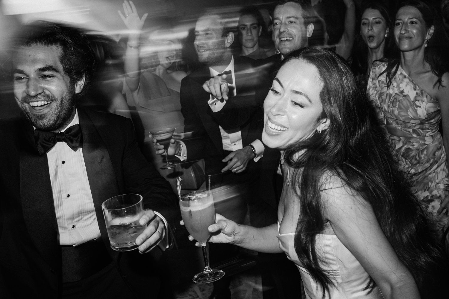 A series of black and white candid party photos showing people laughing and celebrating at an elegant event.