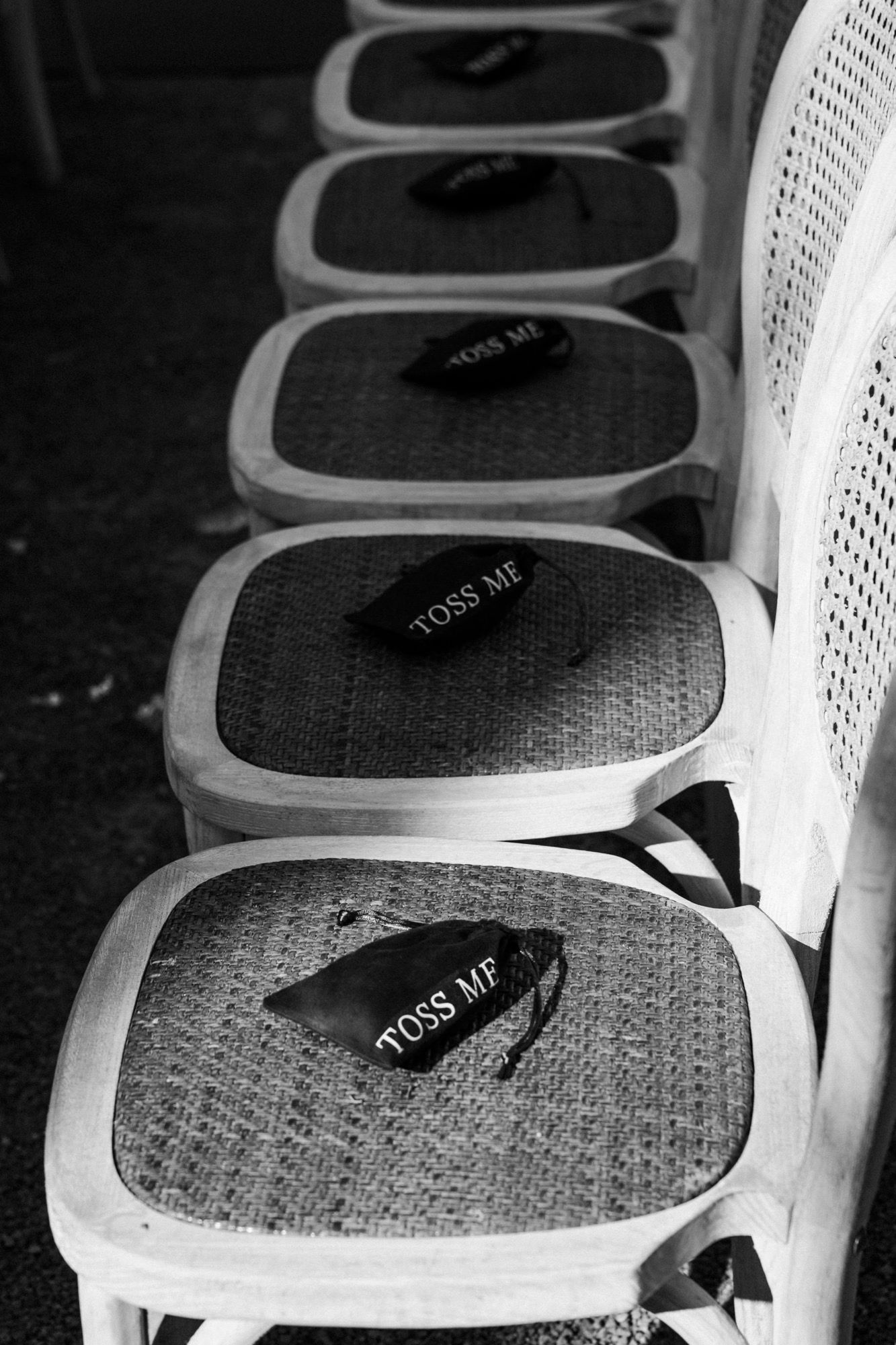 Close-up of vintage-style wedding chairs with decorative mesh backs and black ribbons.