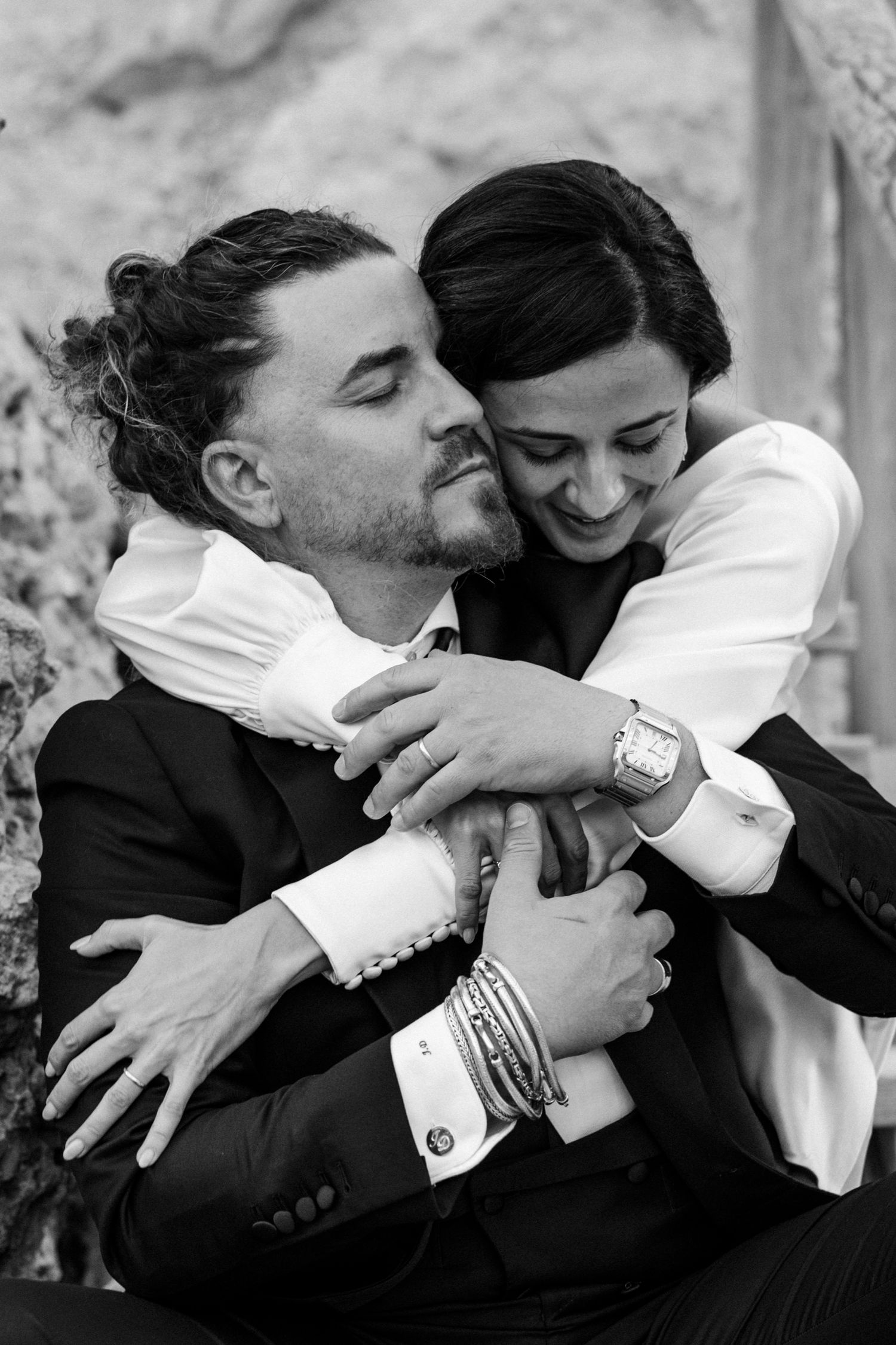 Black and white intimate portrait of couple embracing in formal attire.