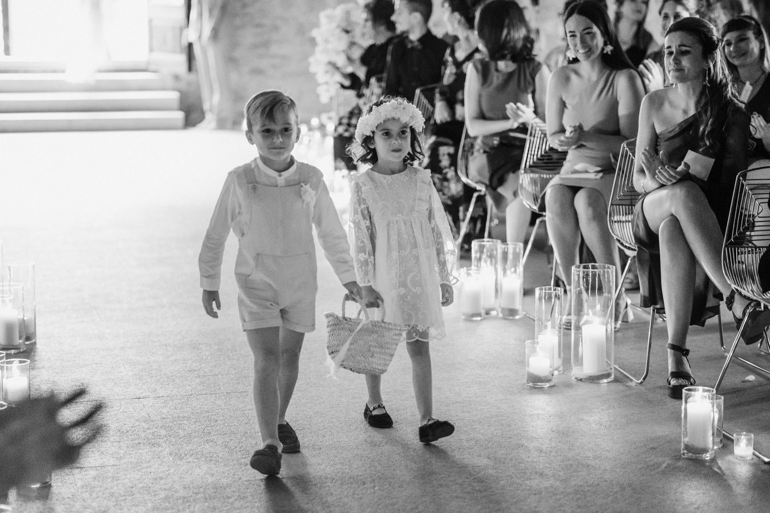 Wedding guests walking through a lantern-lit pathway during an evening celebration.