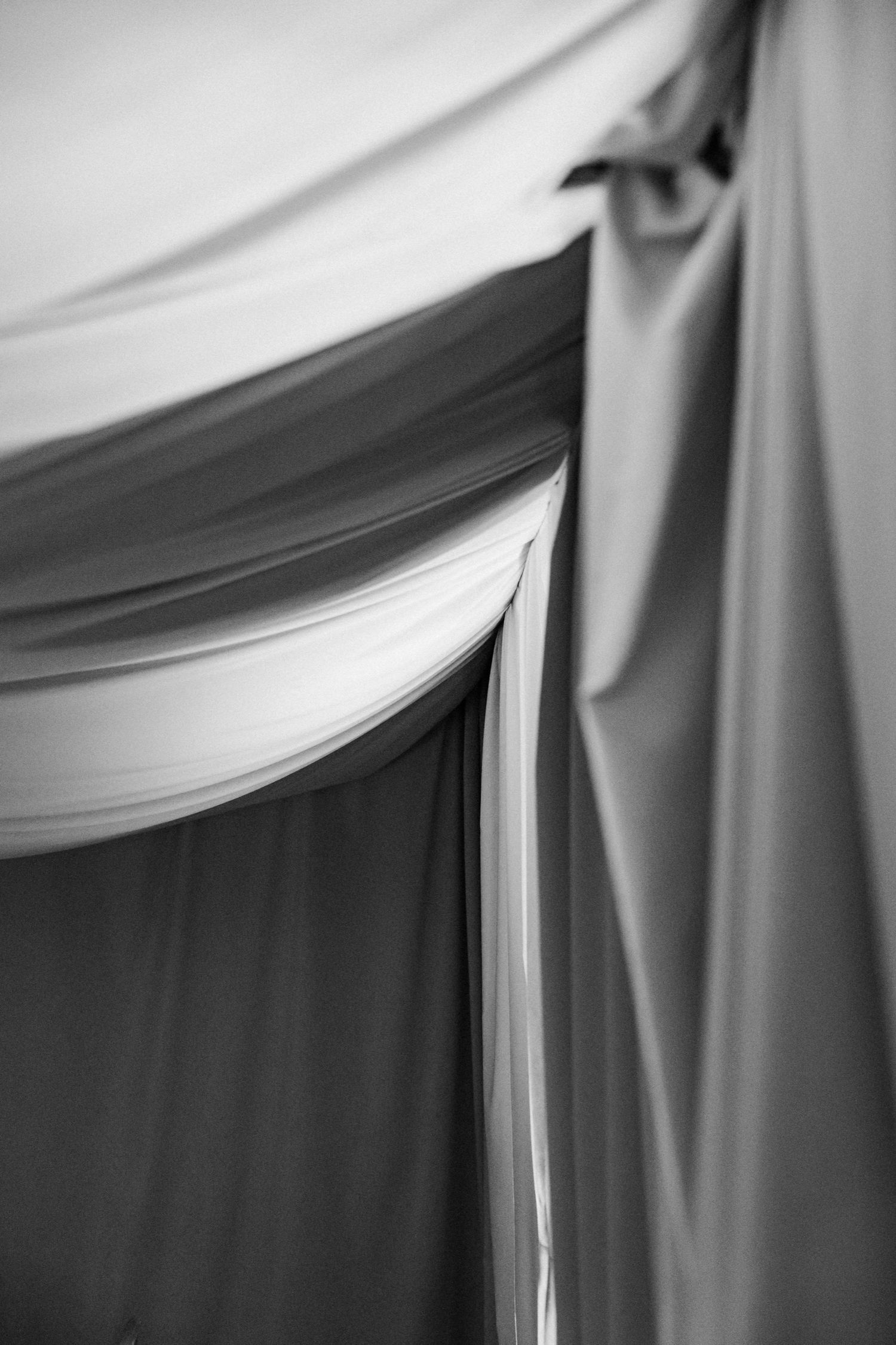 Abstract close-up of white draped fabric with soft folds creating elegant texture.