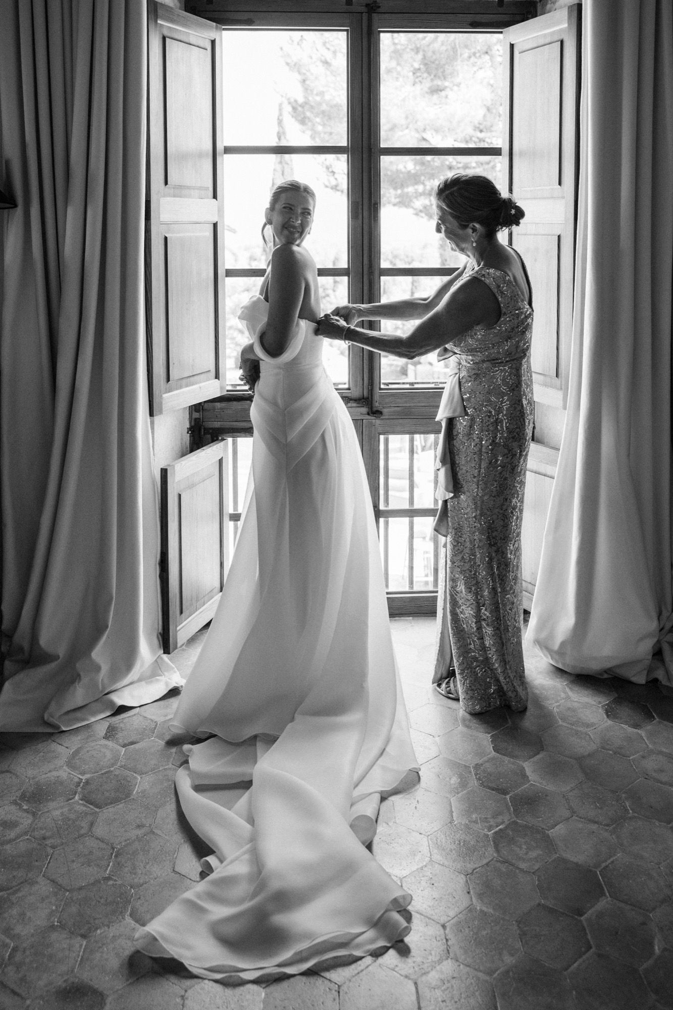 Black and white sequence showing dress preparations by window with natural light.