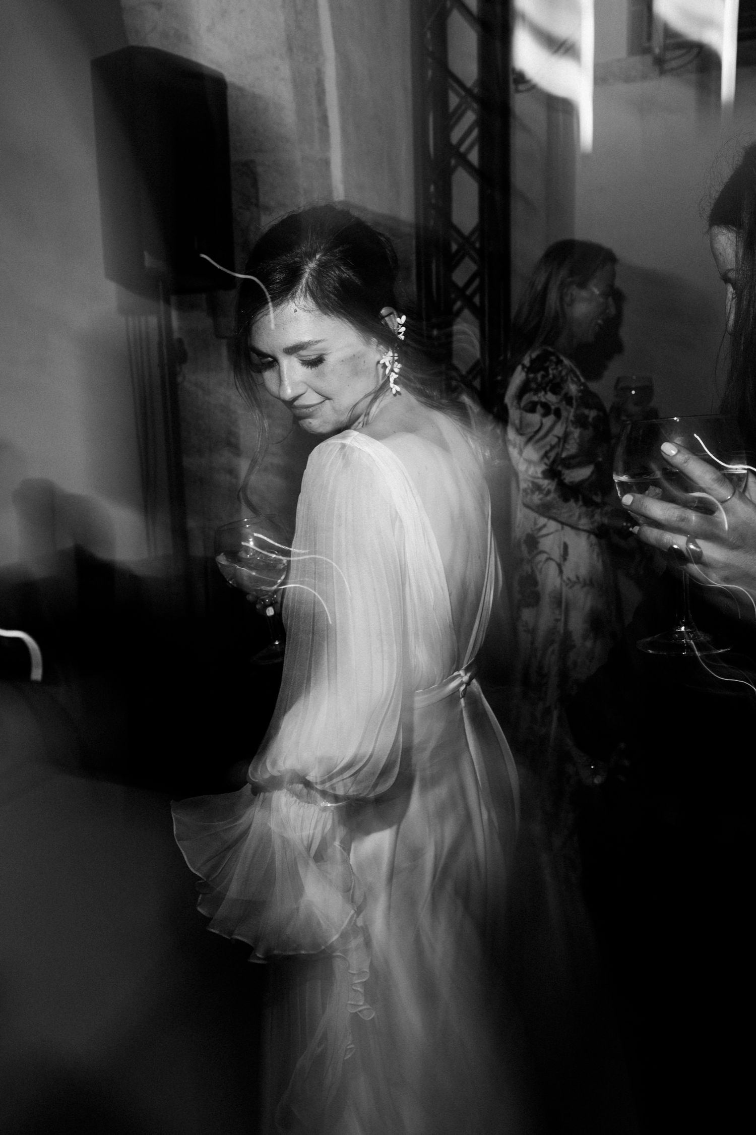 Multiple exposure black and white photograph showing ghostly motion blur of a person in white clothing.