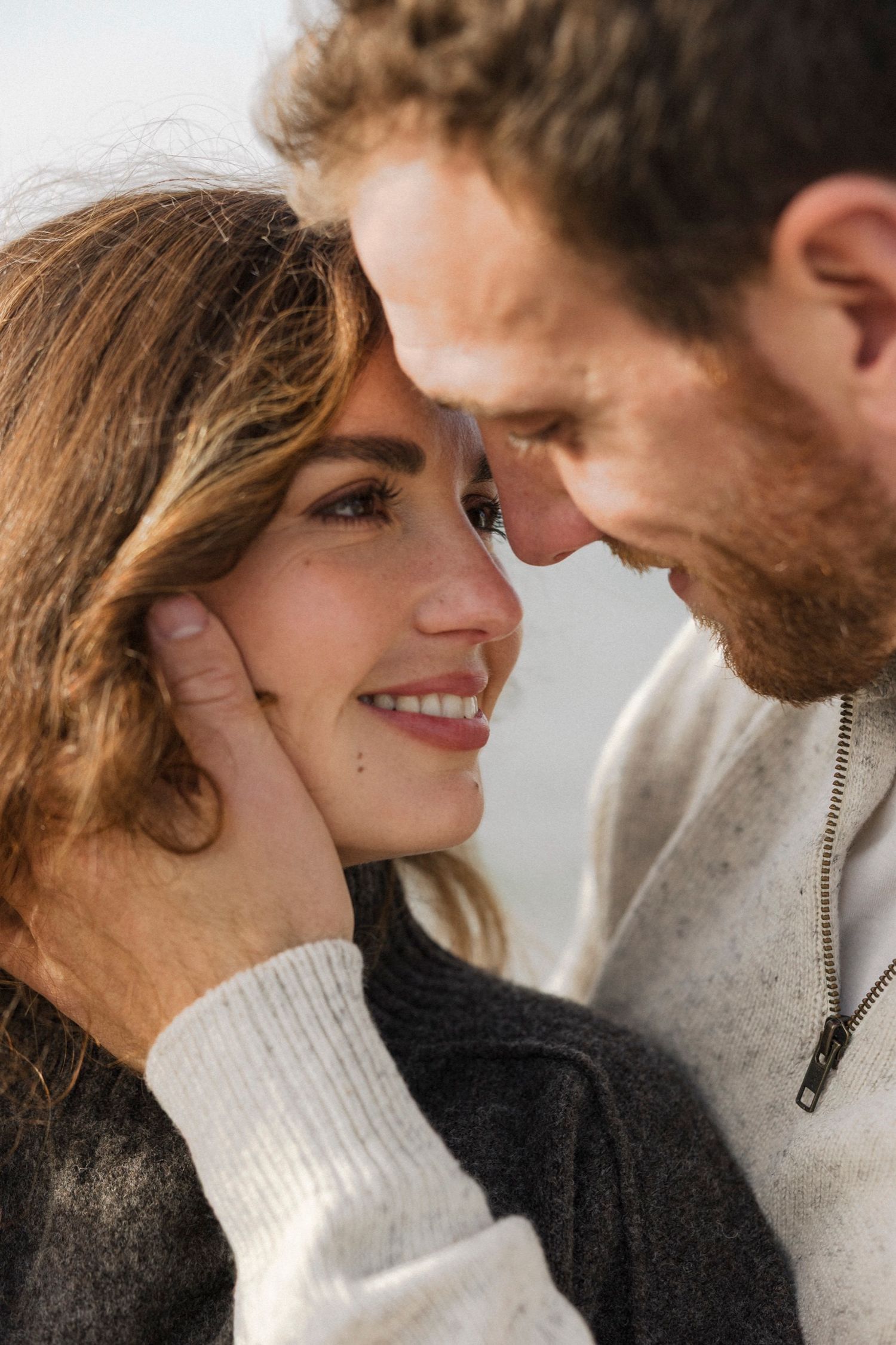 Romantic couple in cozy sweaters share intimate moments in a sequence of tender close-up photos.