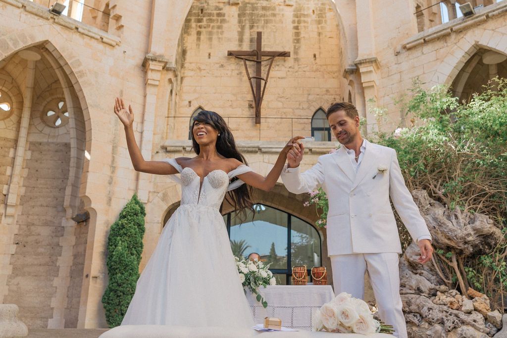 Ancient stone church courtyard decorated for elegant outdoor wedding ceremony.