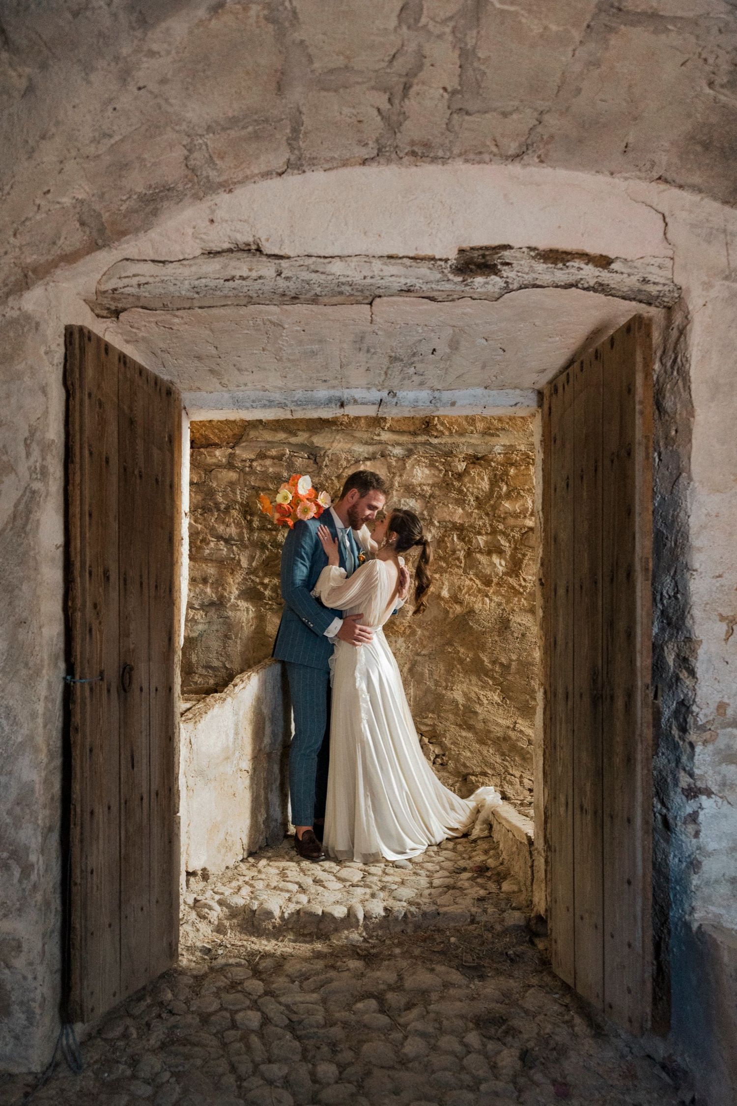 A romantic wedding photo sequence showing a couple in a rustic stone alcove with dramatic lighting and shadows.