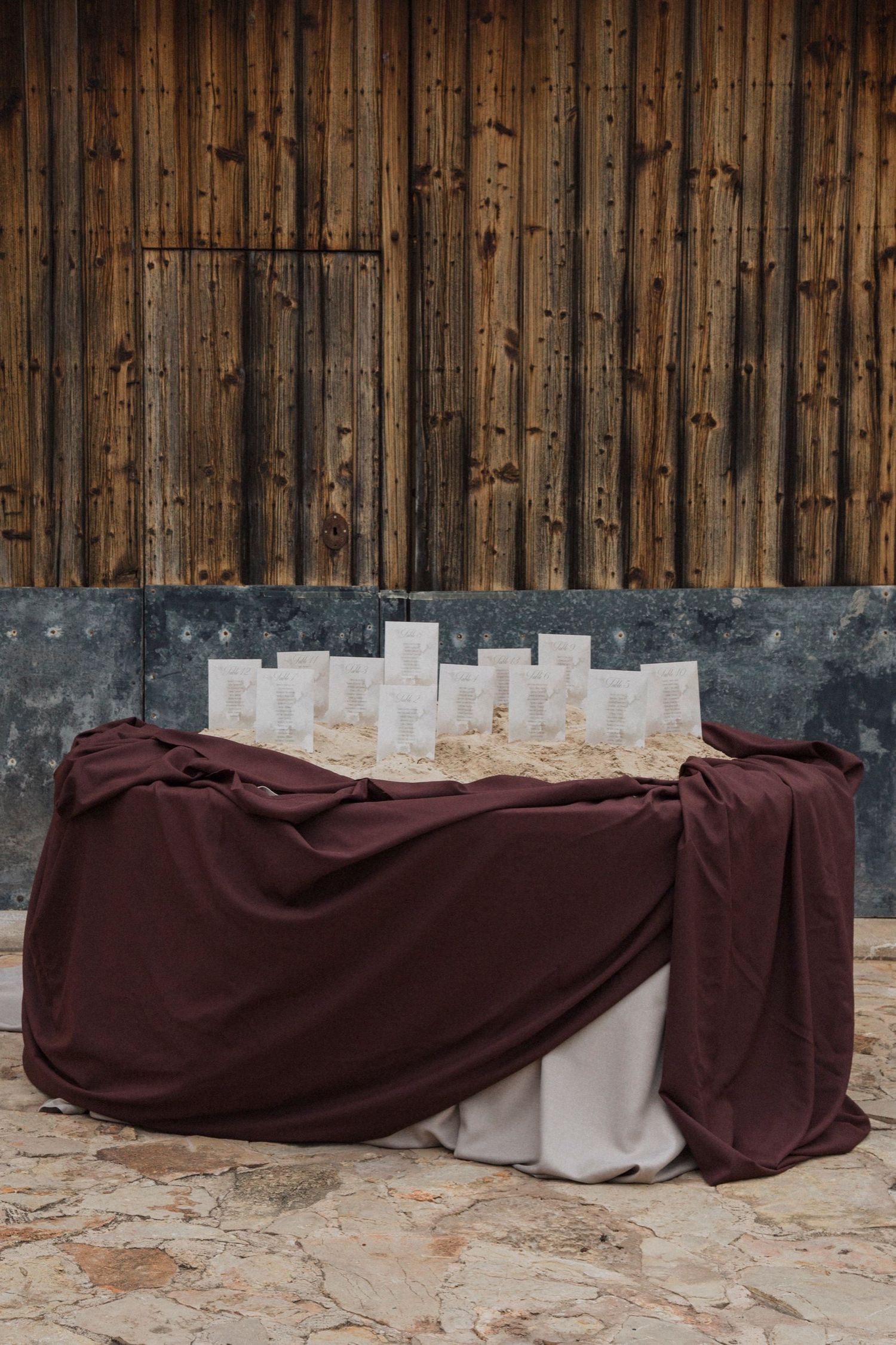 Five sequential images show a brown tarp being gradually pulled over a concrete base against a wooden wall background.
