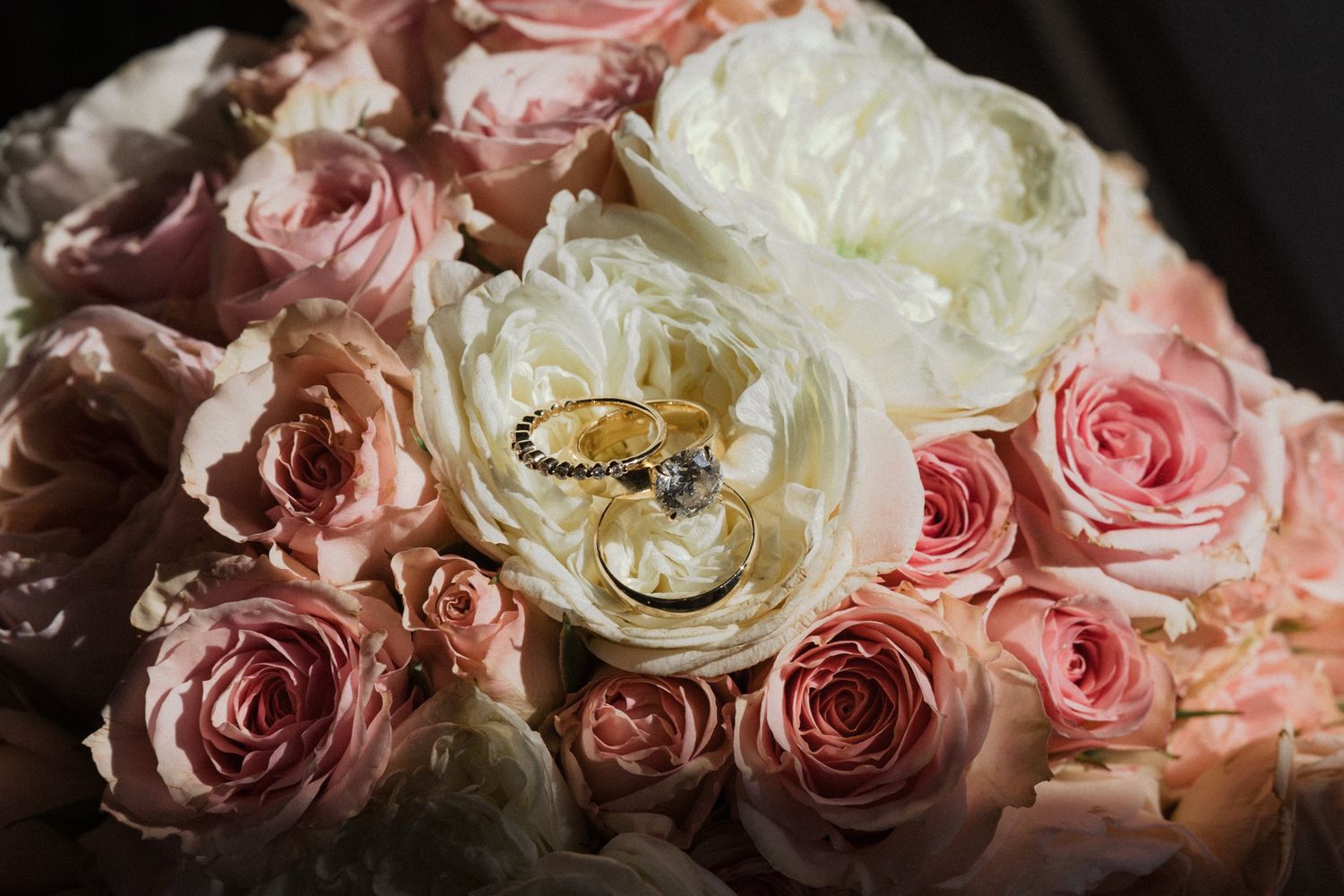 A close-up view of delicate pink and cream roses arranged in a soft, romantic composition.
