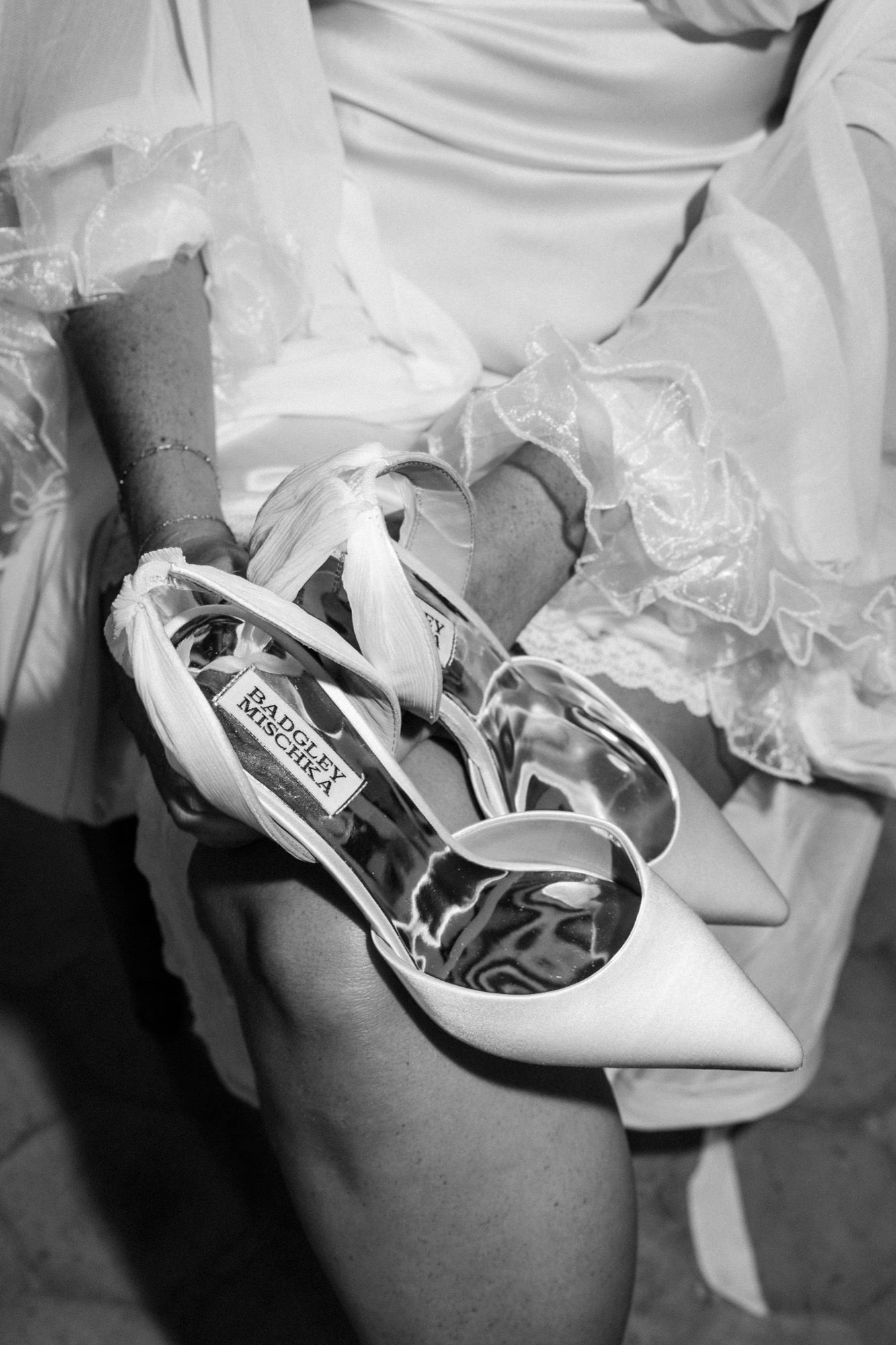 Close-up details of elegant white bridal shoes with delicate fabric.