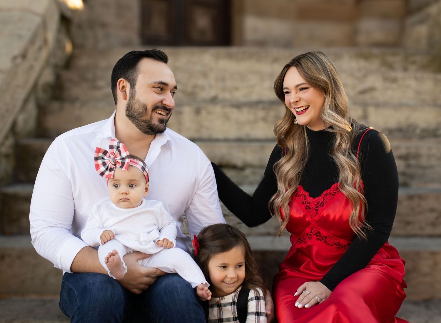 Loving family moment captured on stone steps during holiday photo session.