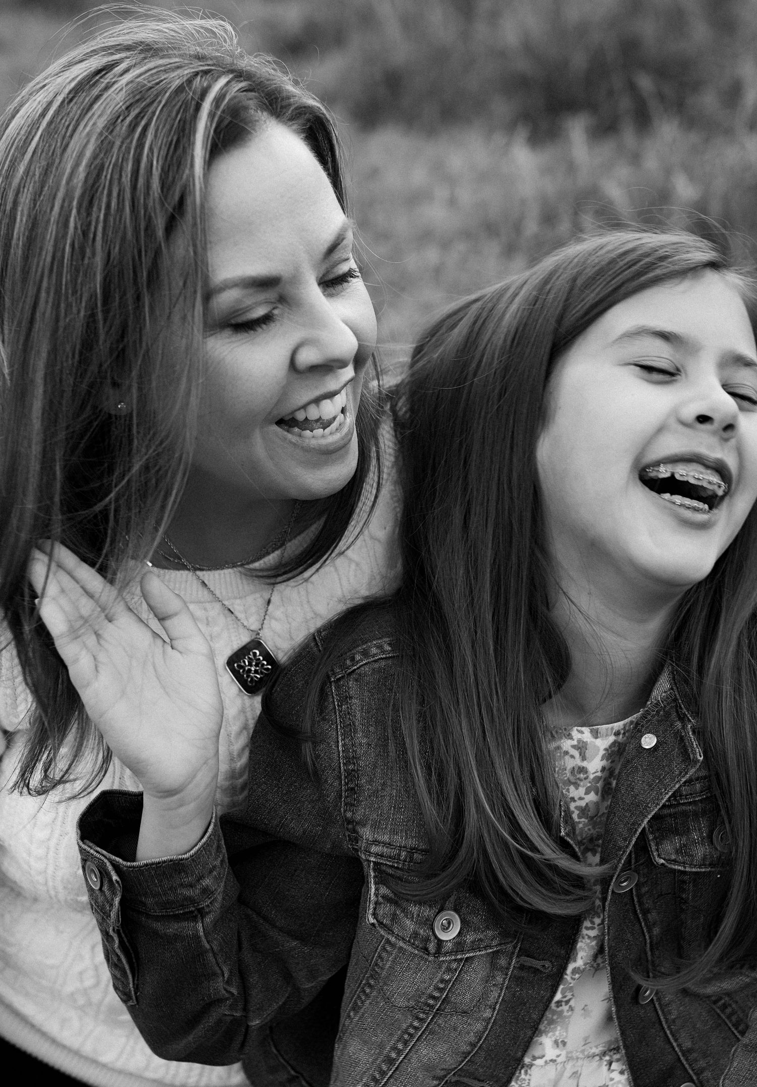 Black and white portrait of two people sharing genuine laughter and joy.