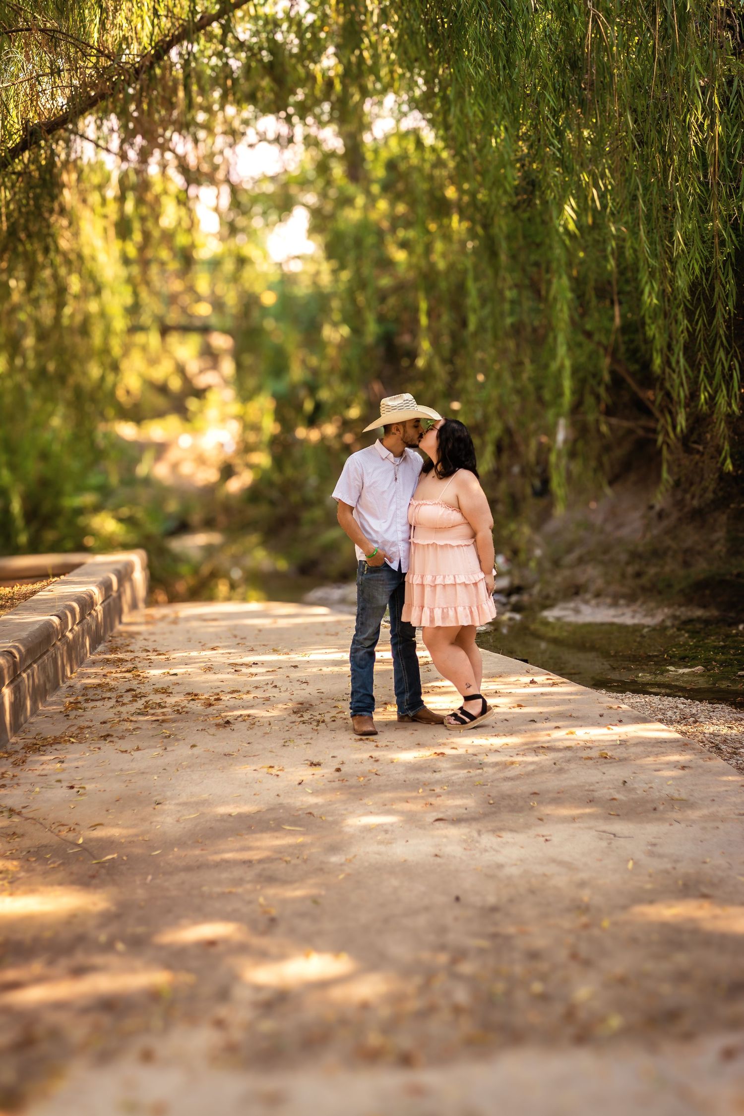 A couple poses at Airfield Falls Trailhead in Fort Worth, Texas for the engagement portrait session.
