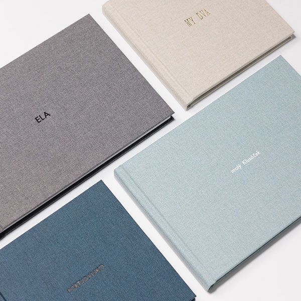 A collection of minimalist business cards or notepads arranged in a diagonal pattern featuring soft grey and blue tones.