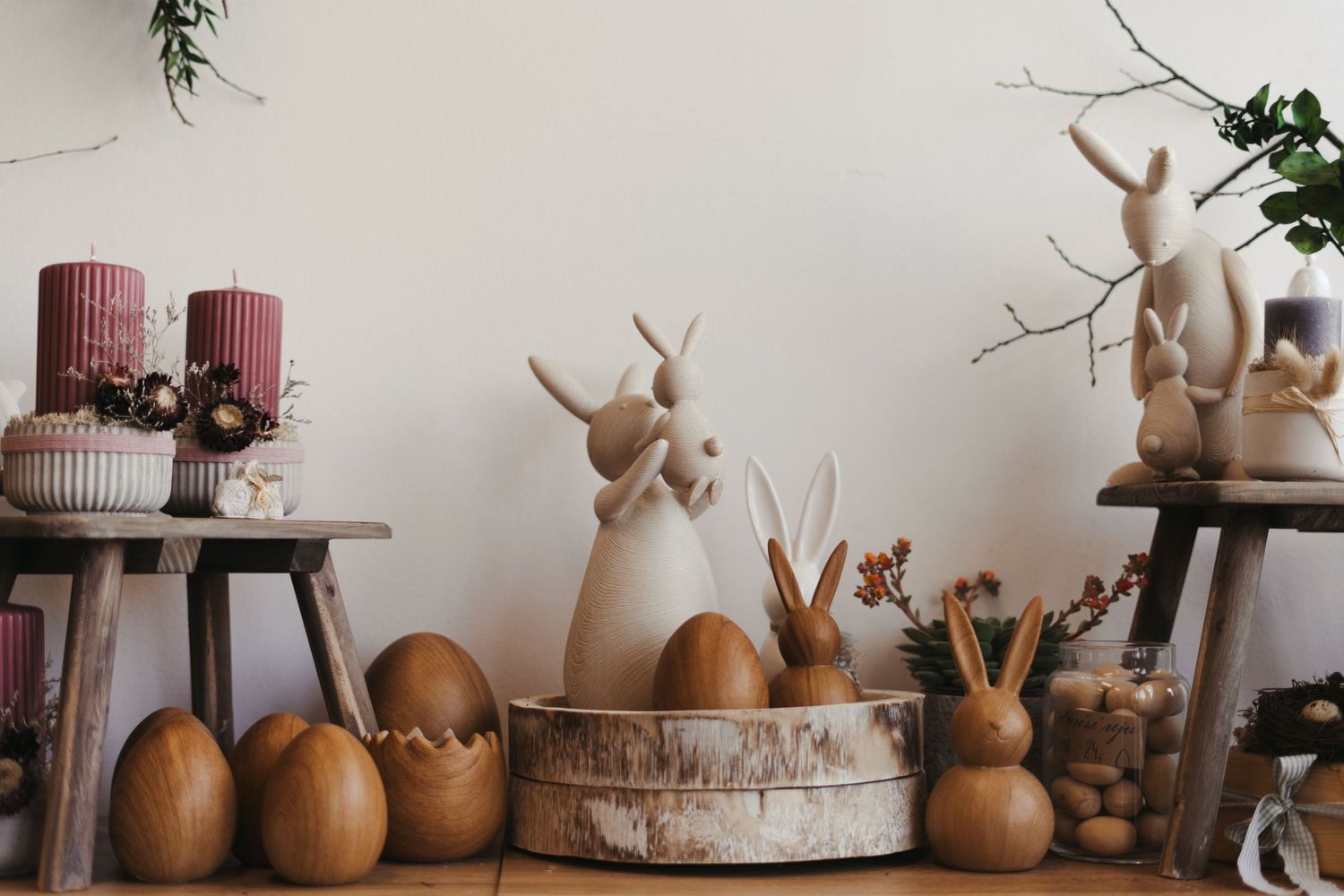 Ceramic deer sculptures and candles arranged on a table create a cozy winter decor display.