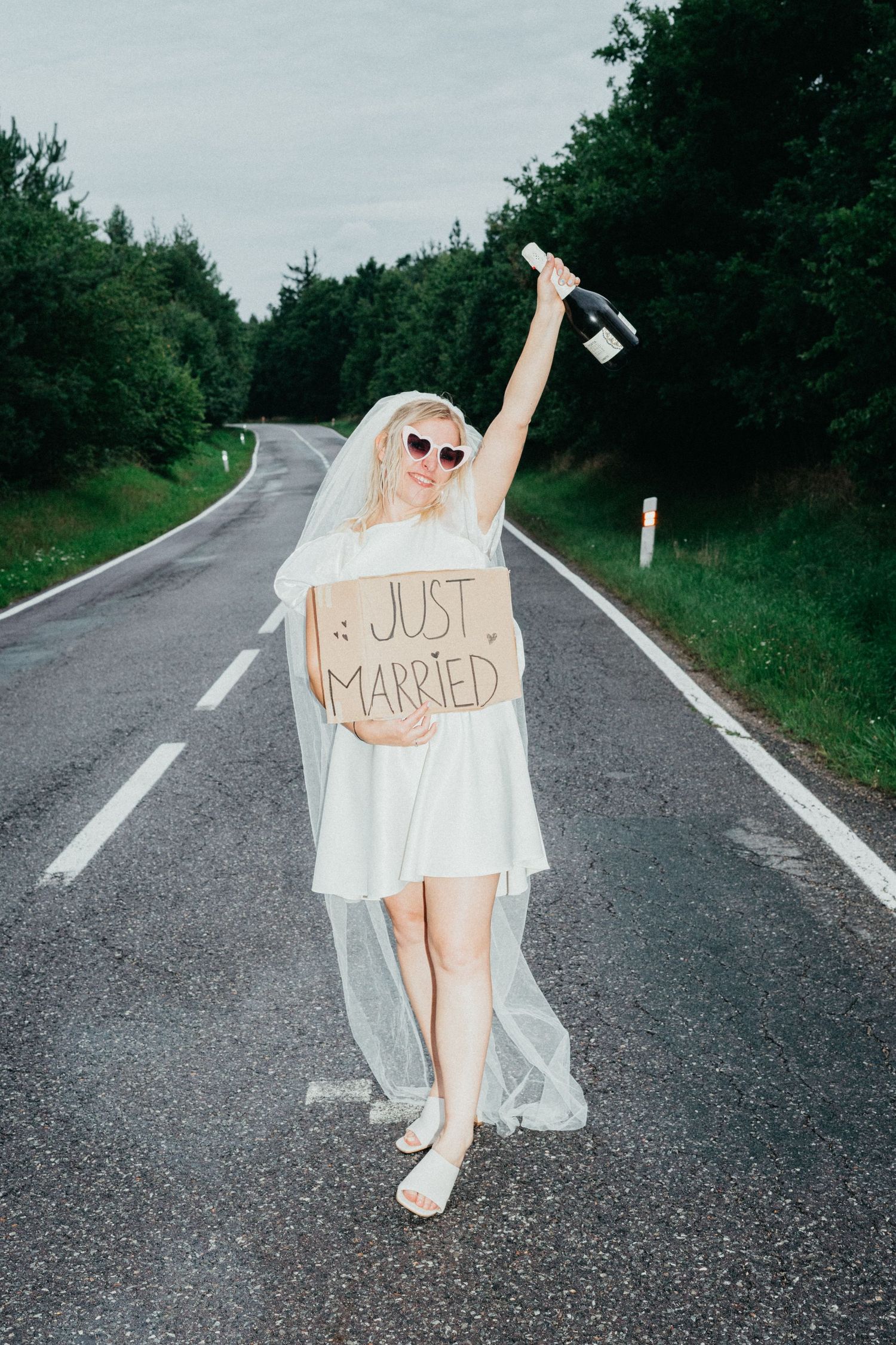 A celebratory figure in a white wedding dress holds a 