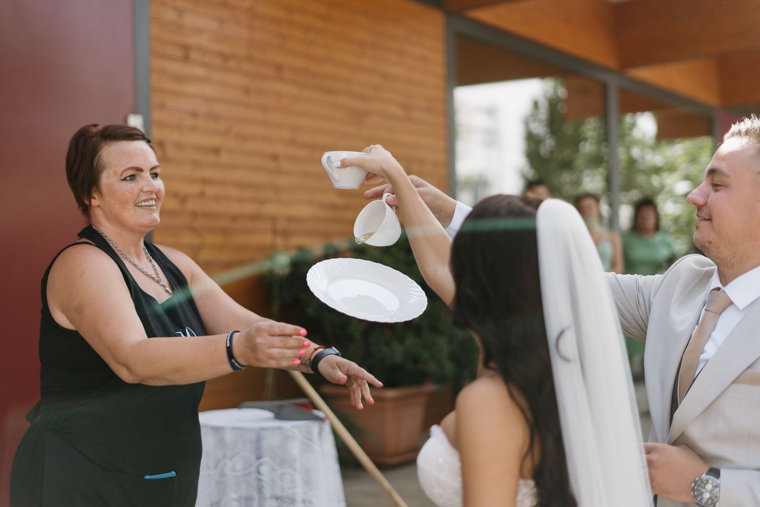 Wedding guests having fun spraying plates with water during the reception celebration.