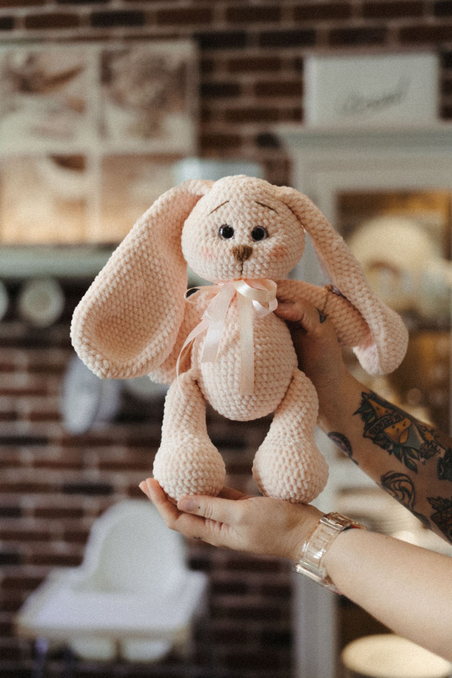 A series of photos showing a small white crocheted elephant stuffed animal with pink ears being posed in different angles.