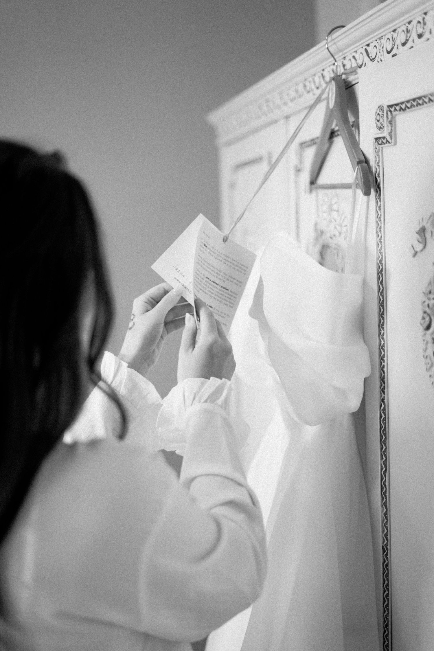 A series of black and white photos shows someone pinning pages to a wall in an artistic display.